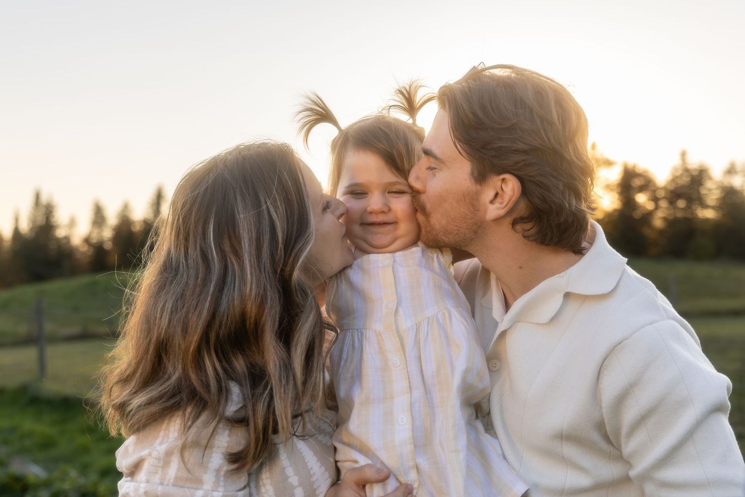 Candid family portrait captures loving interactions during golden hour in an outdoor setting.