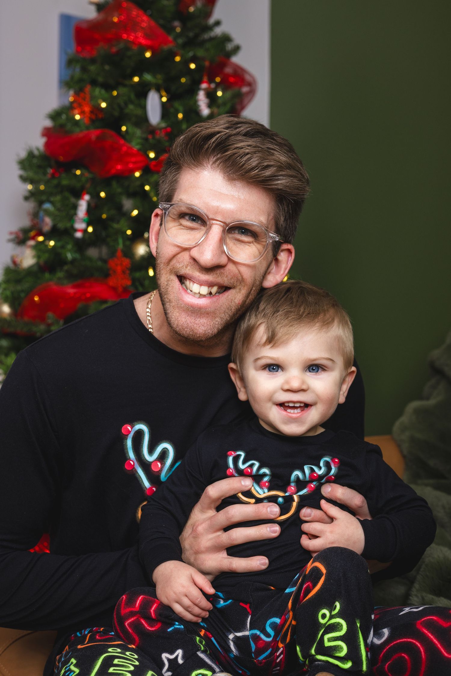 Cheerful holiday photos with matching reindeer sweaters beside Christmas tree with red decorations.
