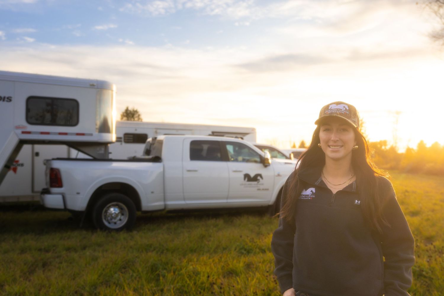 RV trailer parked in grassy field during sunset with warm lighting.