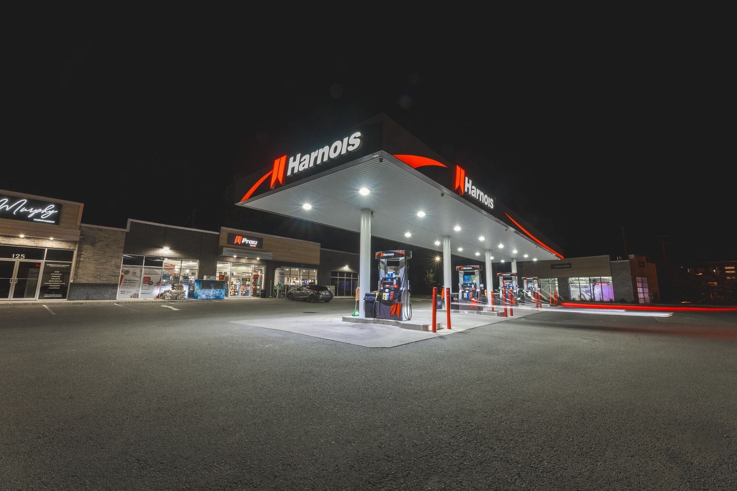 A series of illuminated gas stations at night showing bright canopies and storefront lighting.
