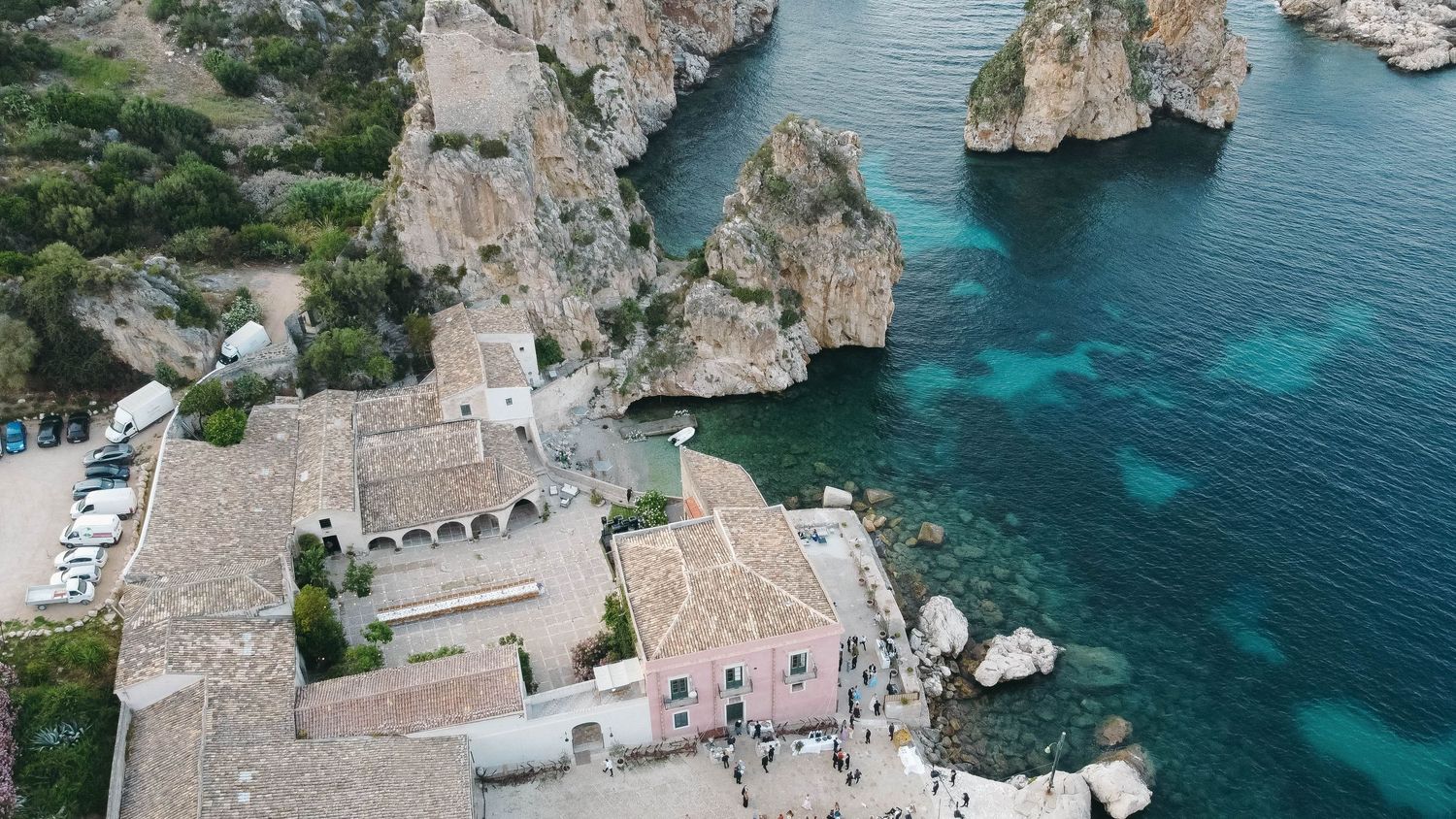 Panoramic view of traditional Mediterranean architecture perched on rugged cliffs by azure seas.
