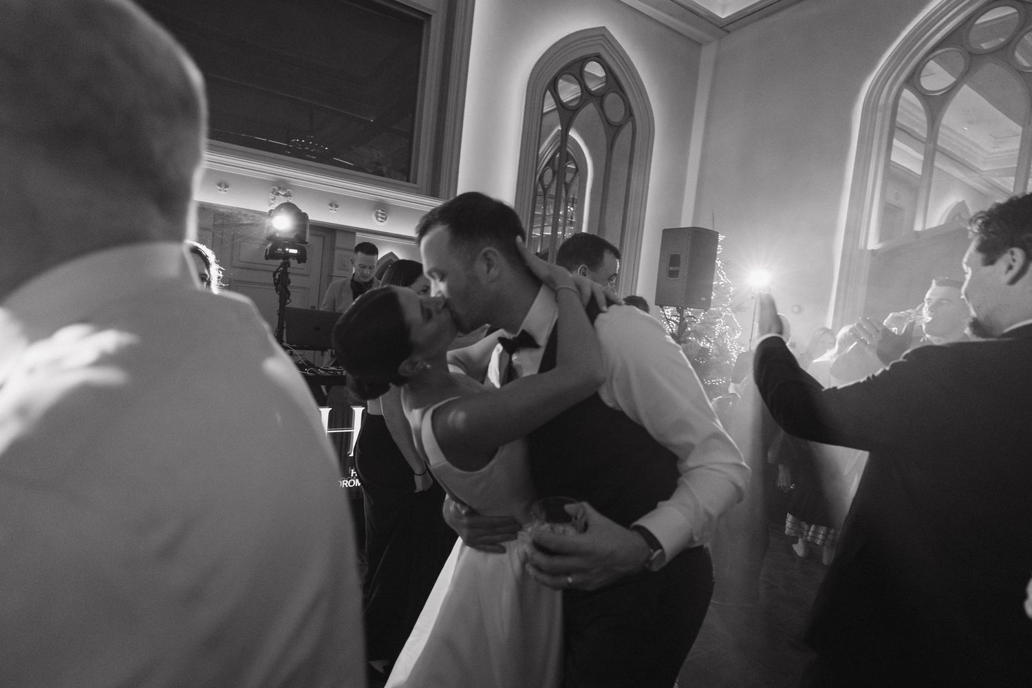 Couple sharing their first dance at a dimly lit wedding reception.