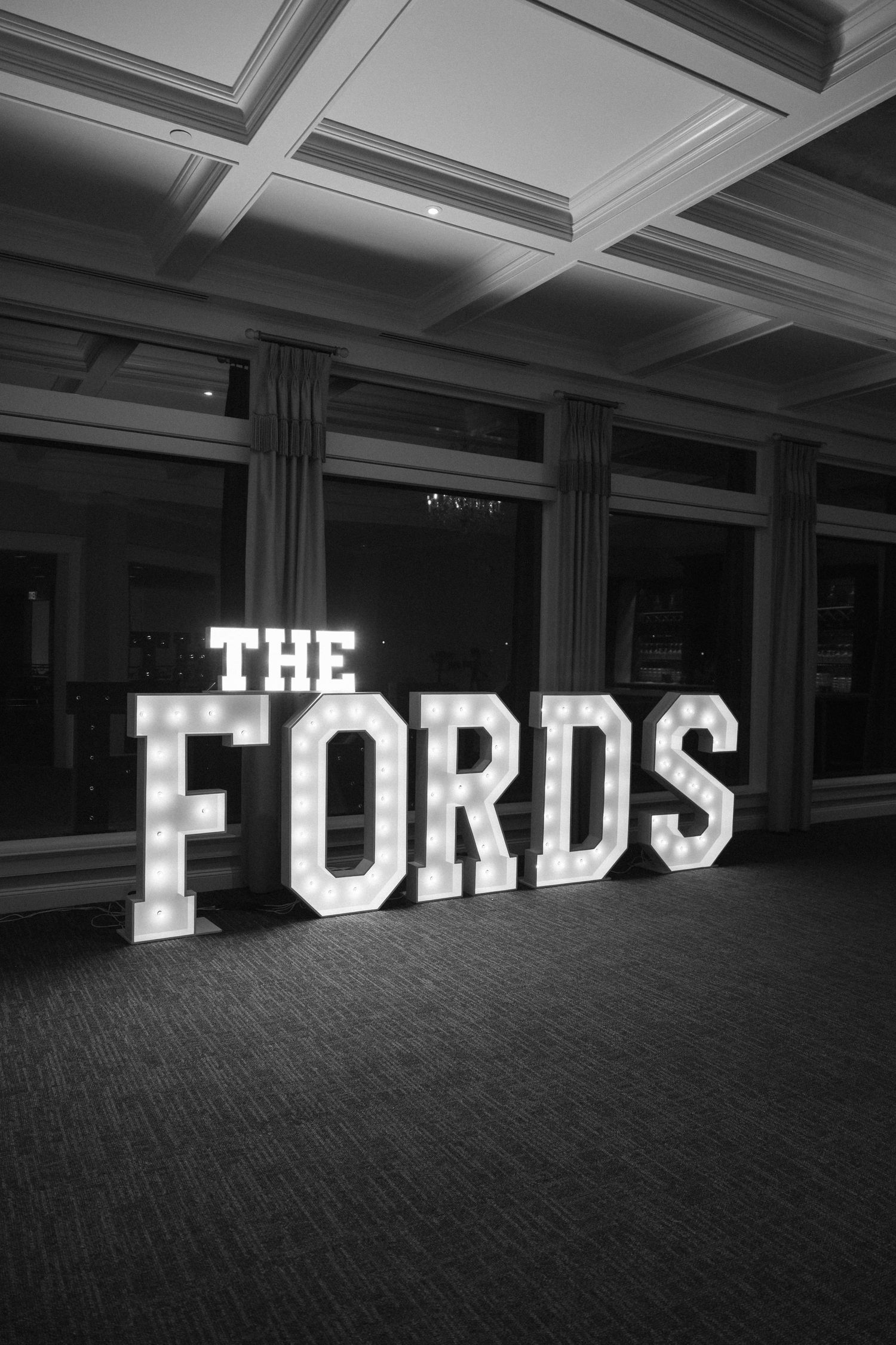 Illuminated marquee letters spelling 'THE FORDS' displayed in a venue space.