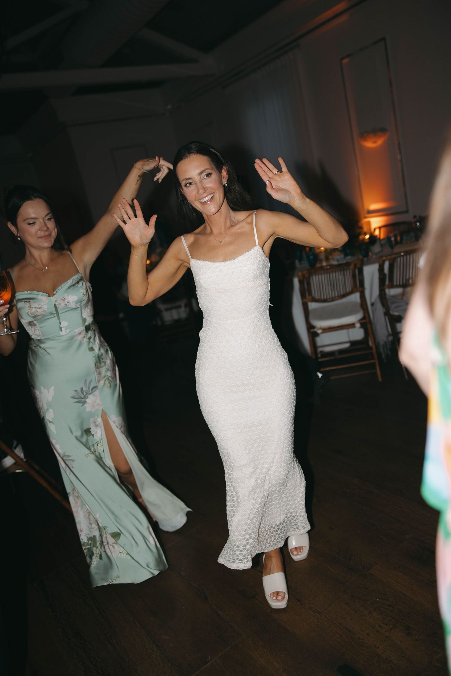Wedding guests dancing and celebrating on the dance floor.