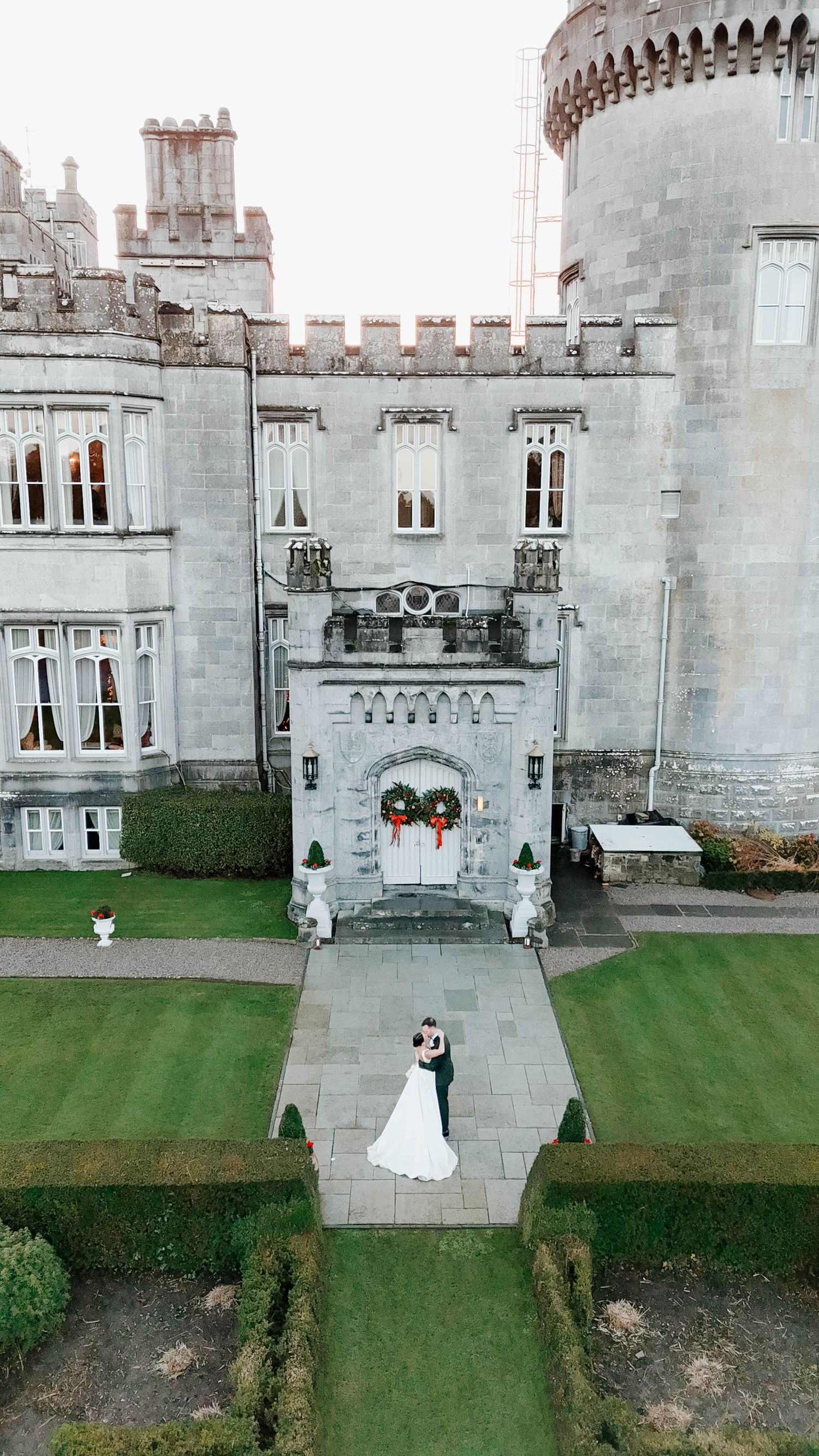Majestic stone castle with Gothic architecture and well-manicured lawn in front.