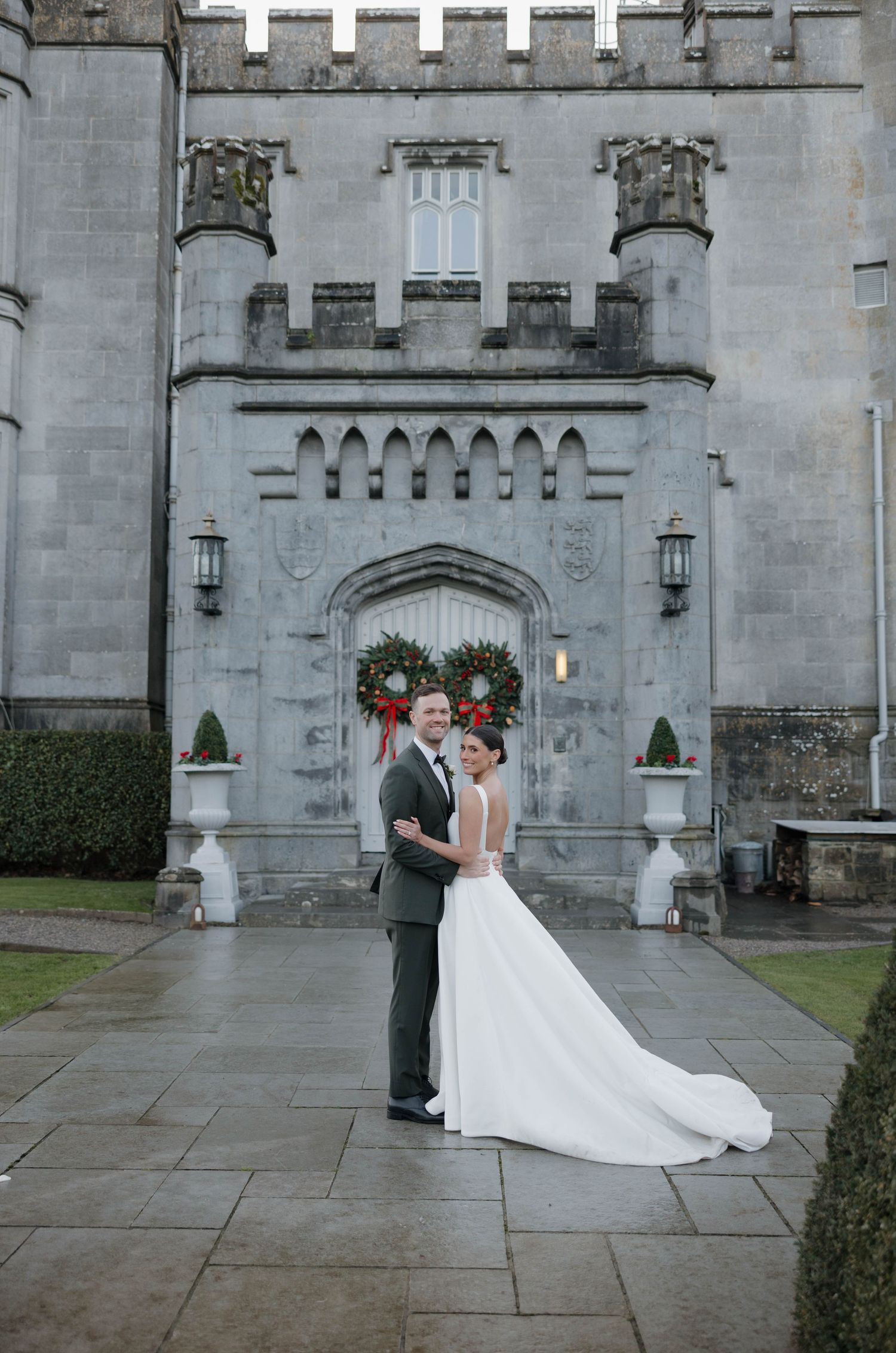 Wedding couple photographed in sequence outside a medieval castle entrance.