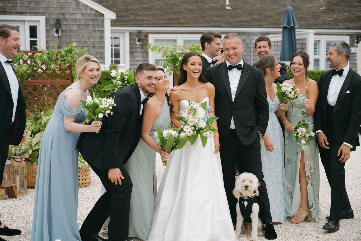 Wedding party members interact playfully during outdoor photo session in formal attire.