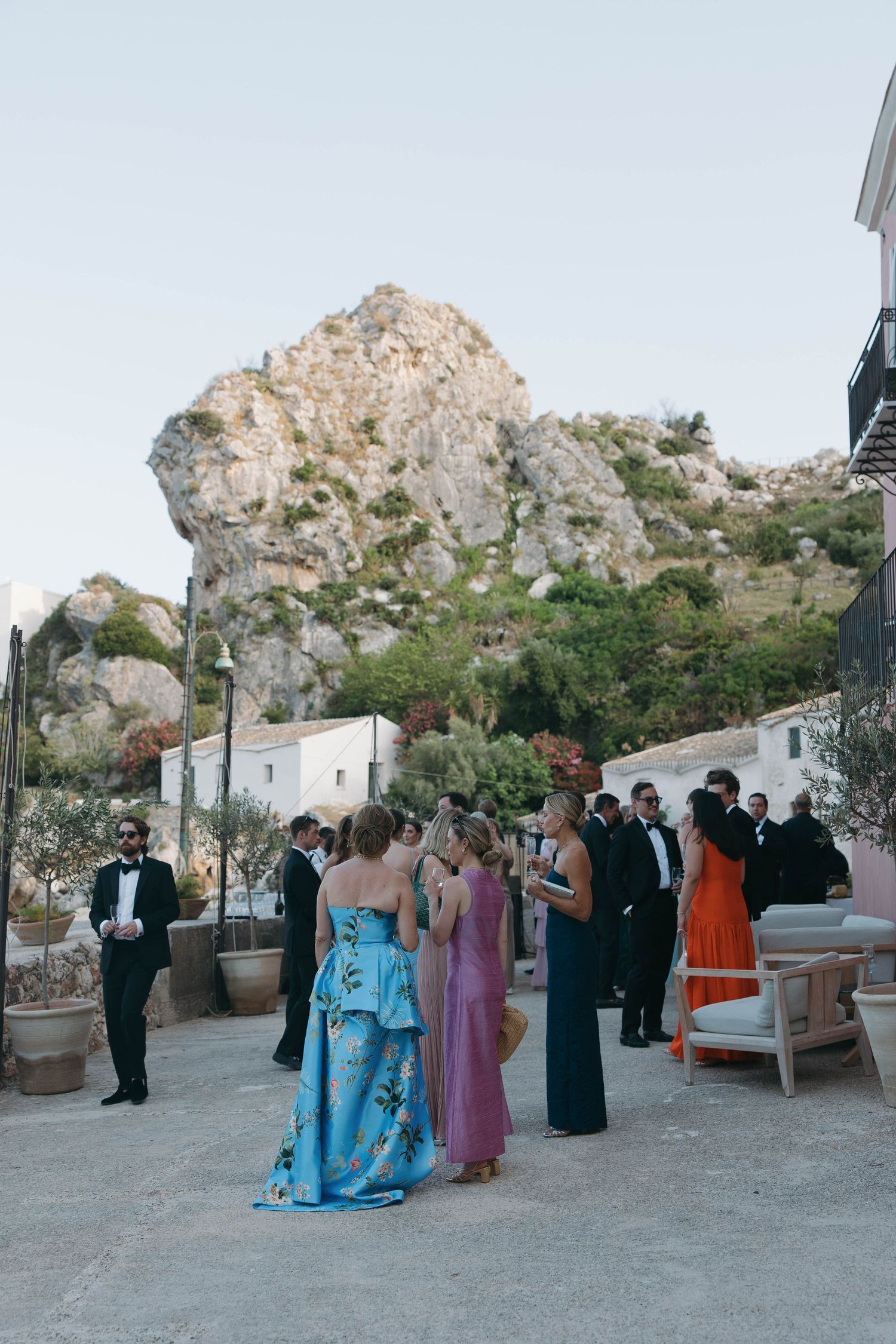 Formal event gathering at a scenic coastal venue with cliffs in the background.