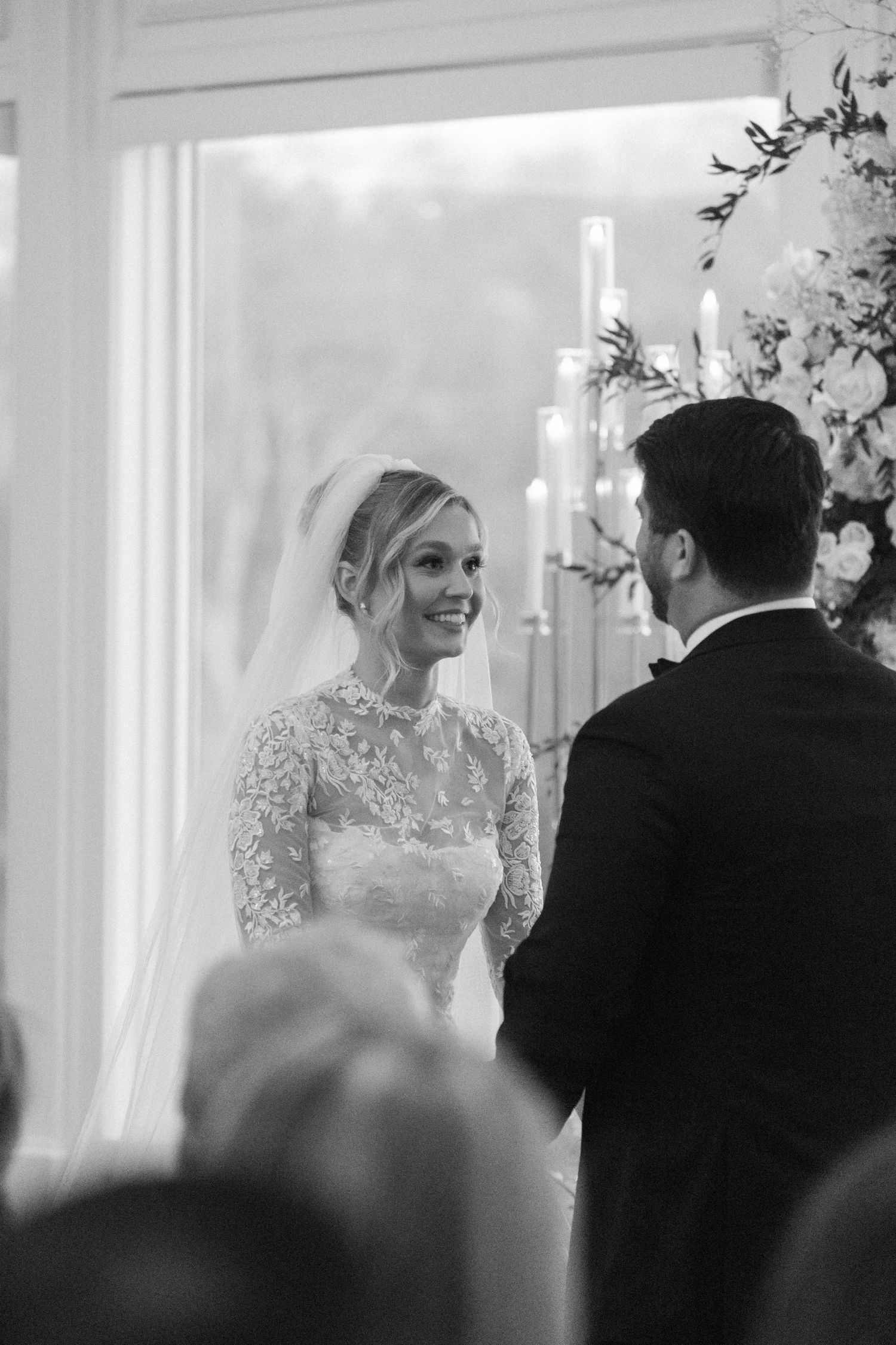 Black and white wedding ceremony photo capturing intimate moments at the altar.