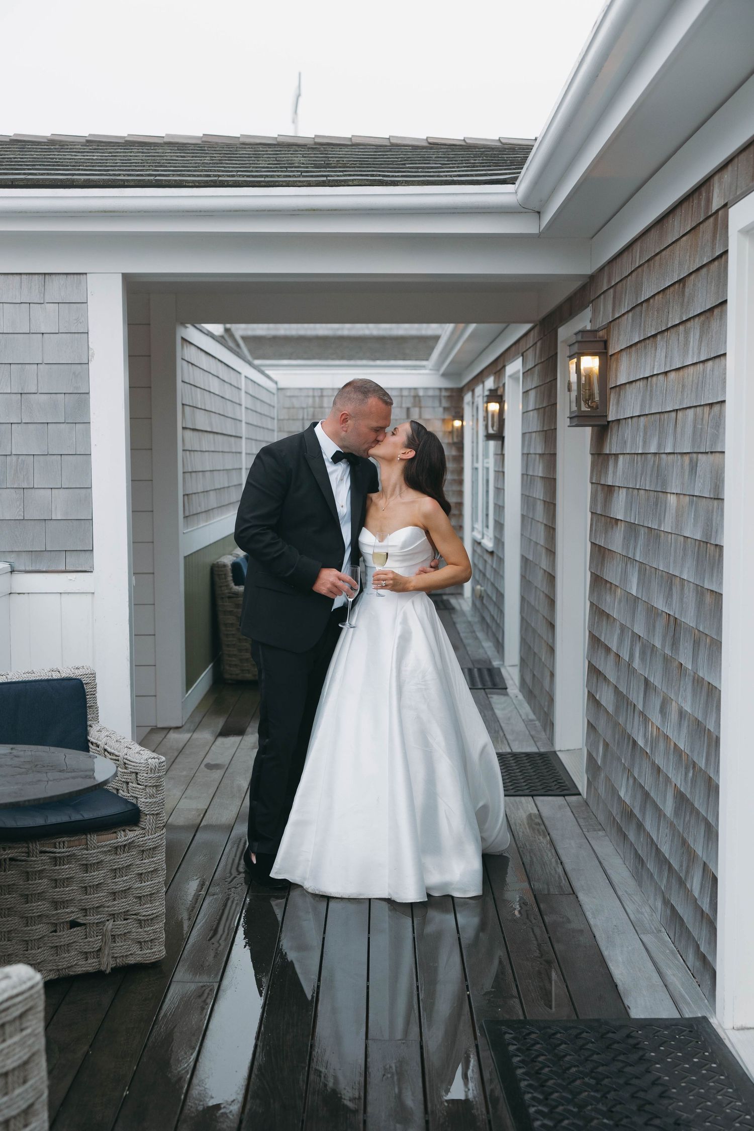 Couple sharing romantic moment on covered walkway with shingle siding.