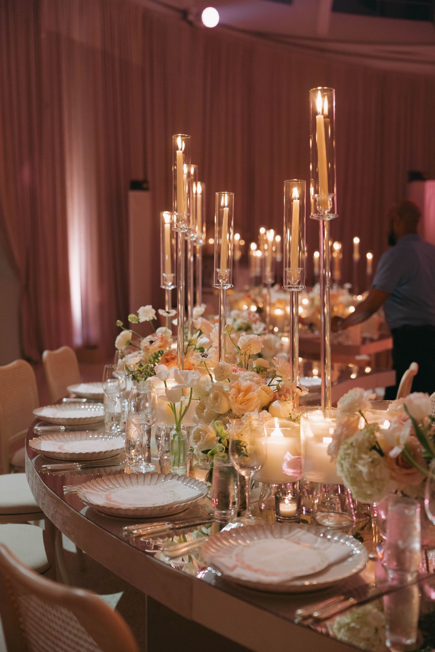 Detailed table setting with crystal candelabras, white china, and delicate floral arrangements.
