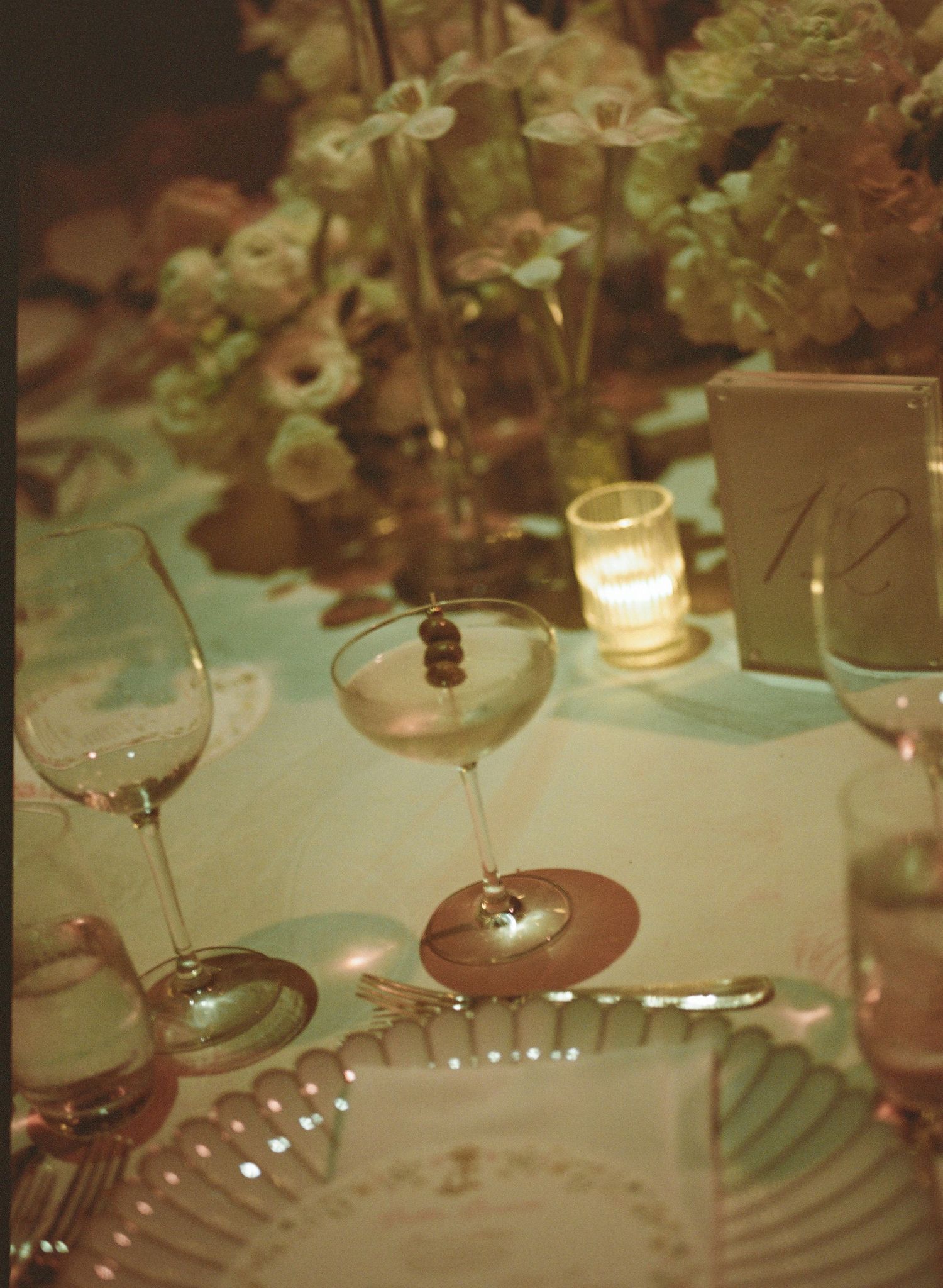 Elegant table setting with wine glasses and floral centerpieces at a formal event.