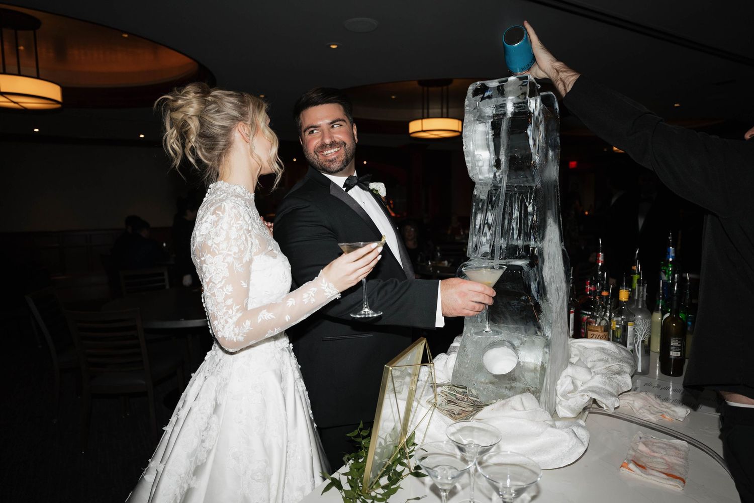 Elegant wedding reception scene with formal table settings and ambient lighting.