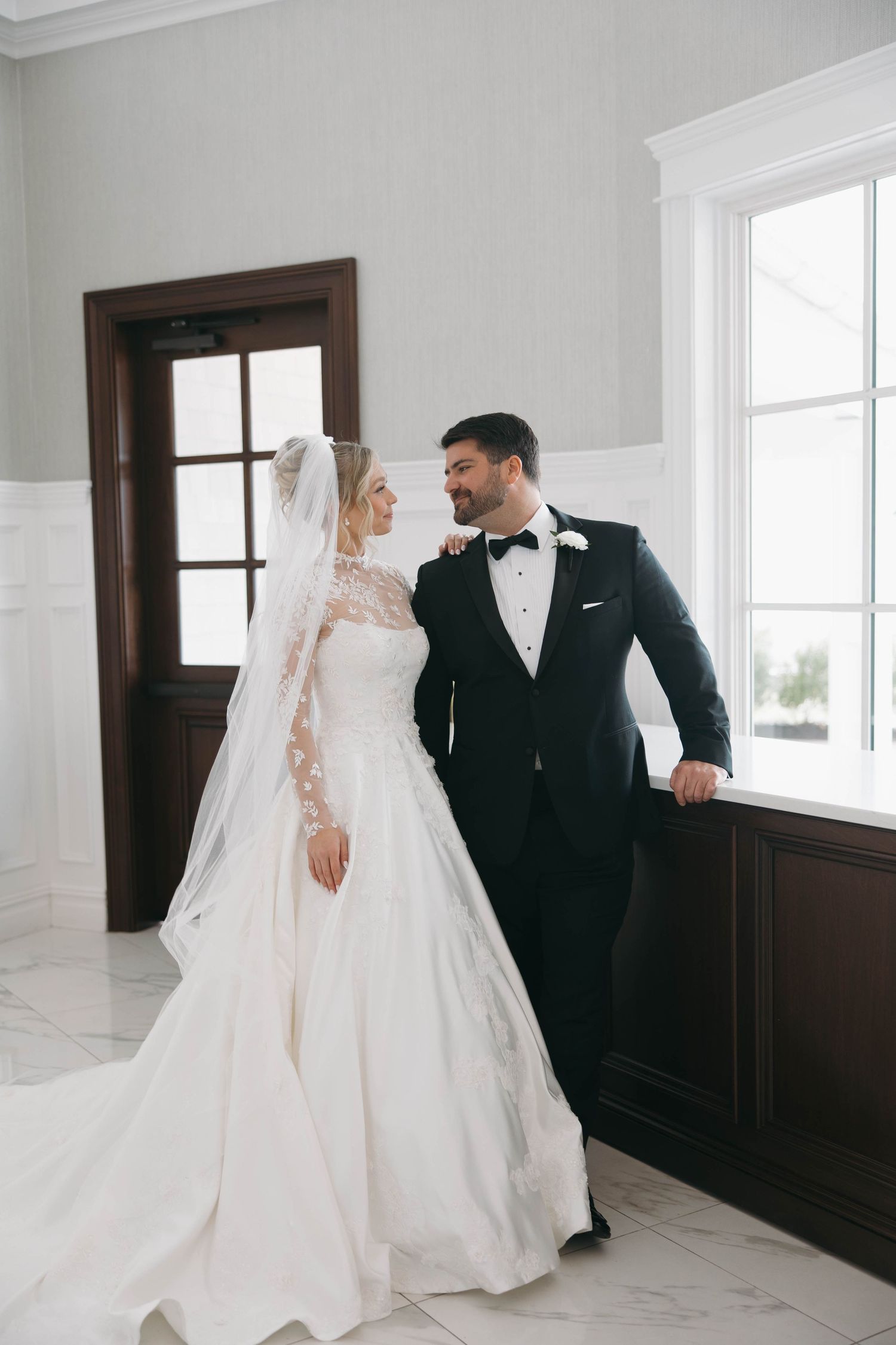 Wedding couple shares intimate moments in a bright modern space with wood details.