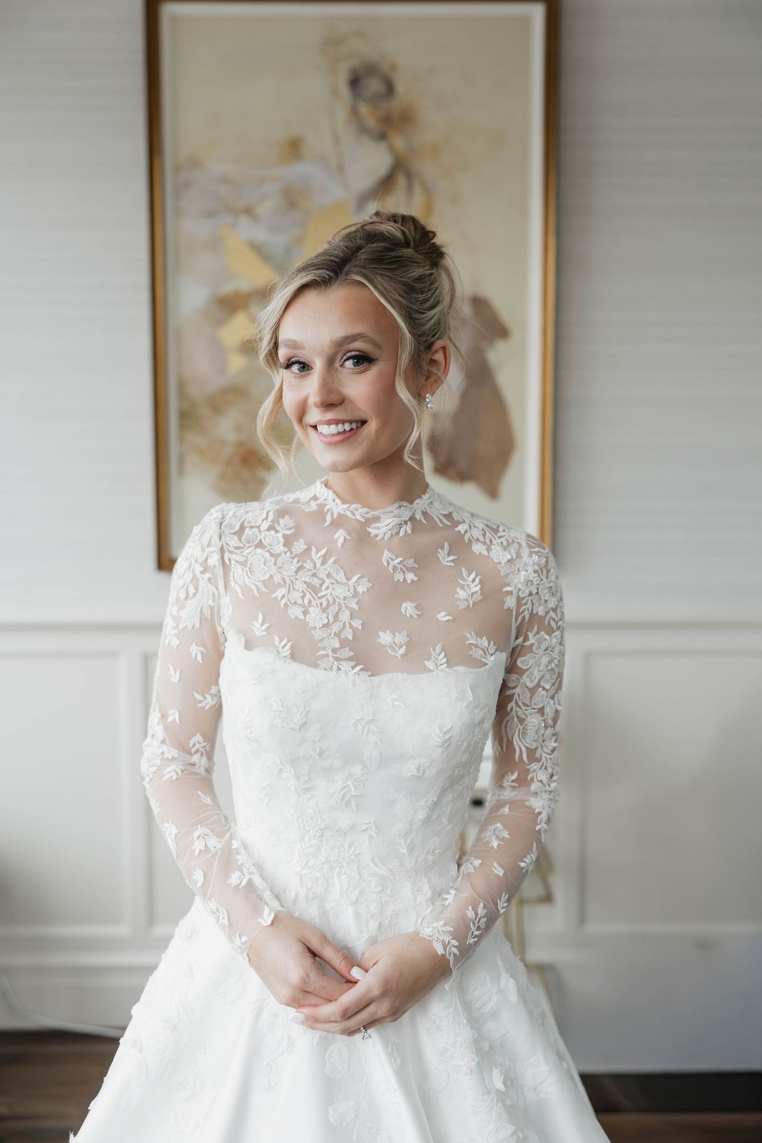 Detailed shot of wedding gown showing delicate floral lace appliques and sheer sleeves.