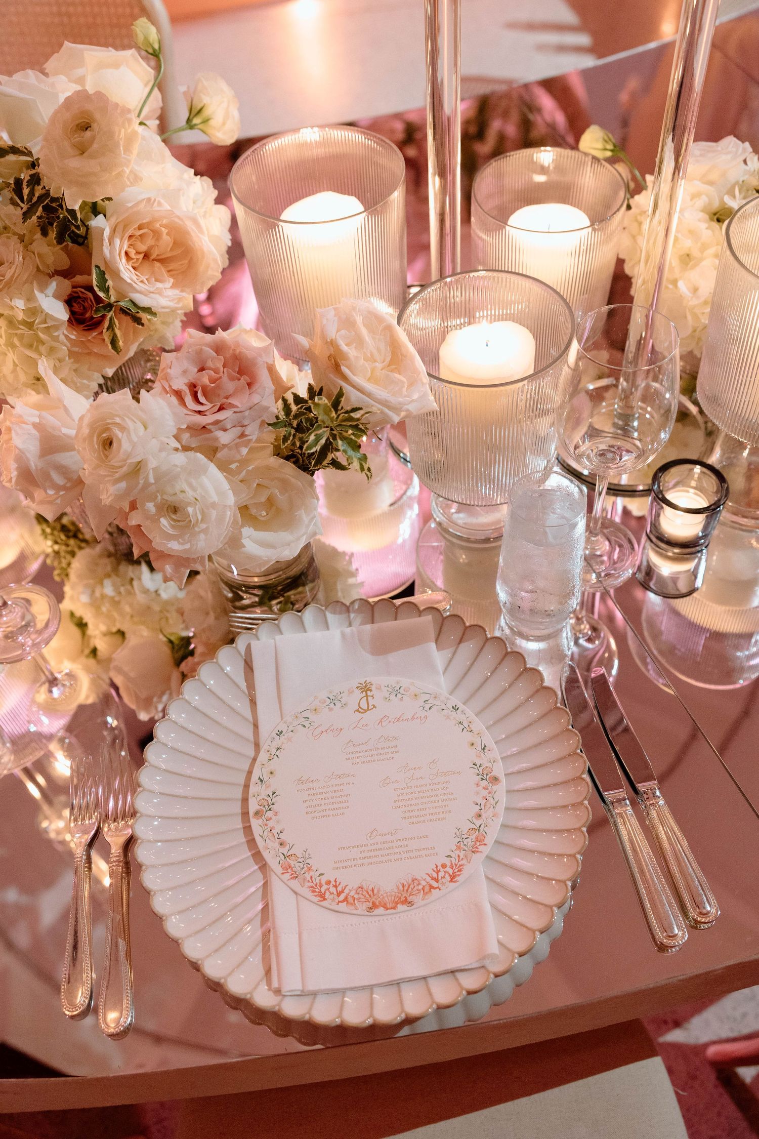 Luxurious place settings with ruffled charger plates, crystal stemware, and delicate floral accents.