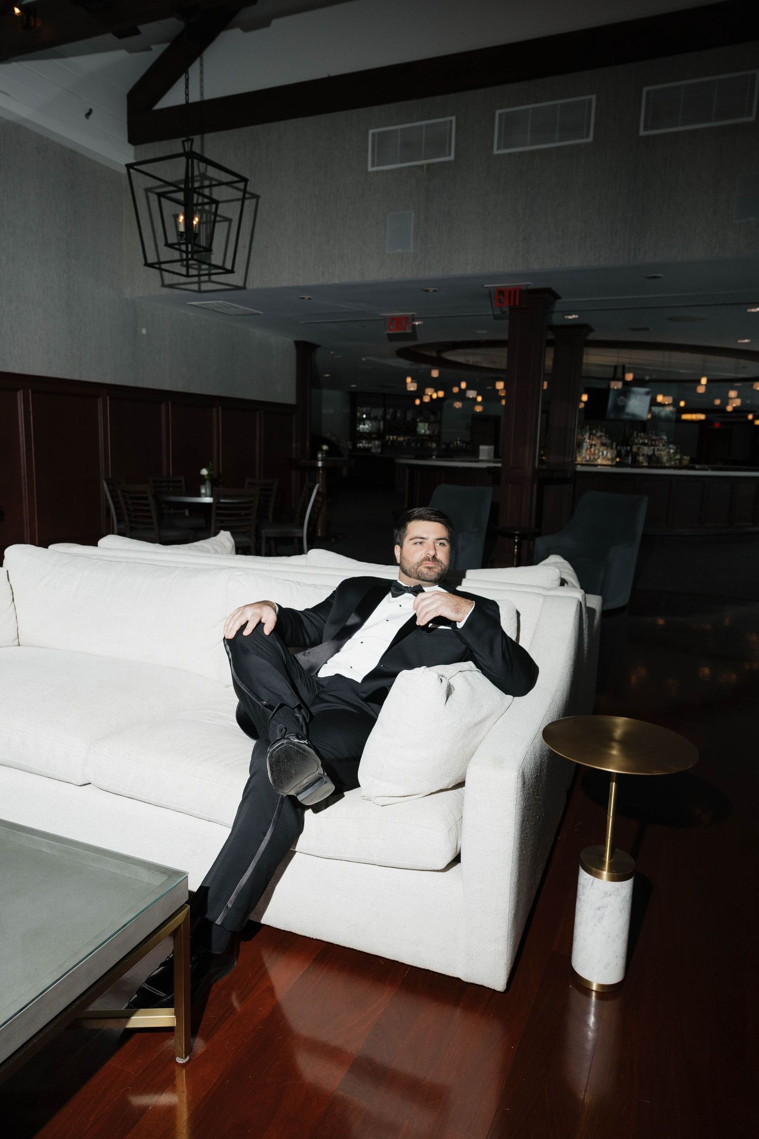 A formal evening scene with a white couch and modern geometric pendant lighting.