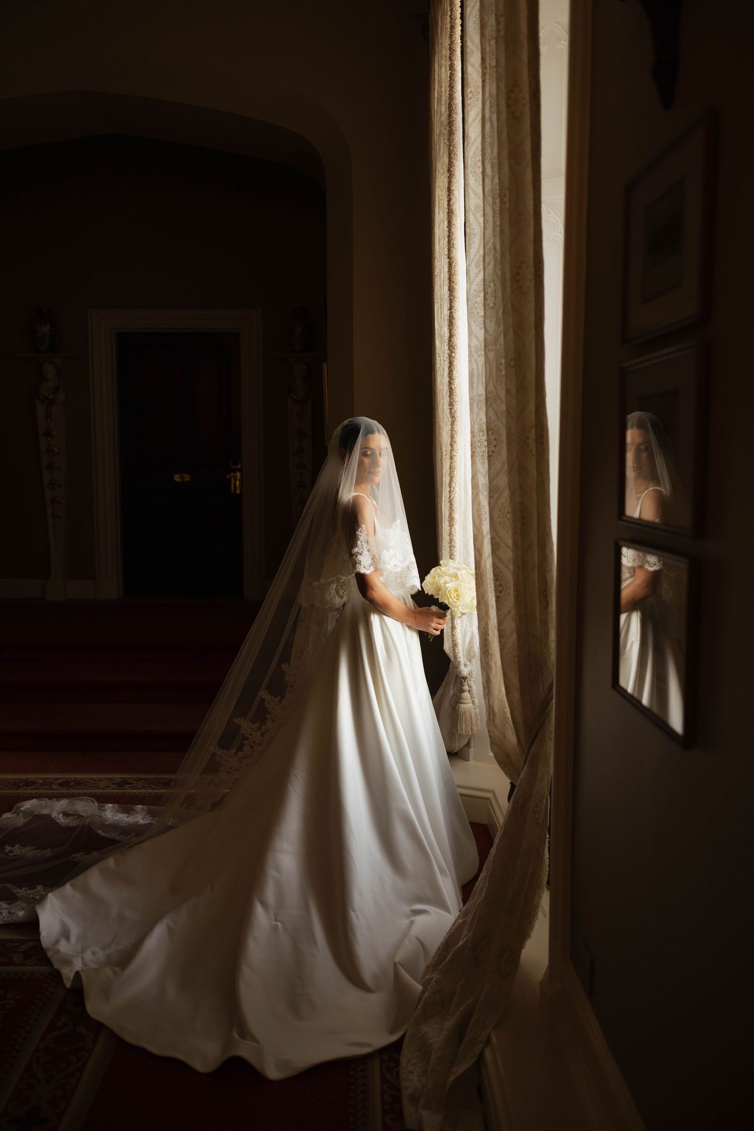 Dramatic window-lit bridal portraits showing the flow of a wedding dress in natural light.