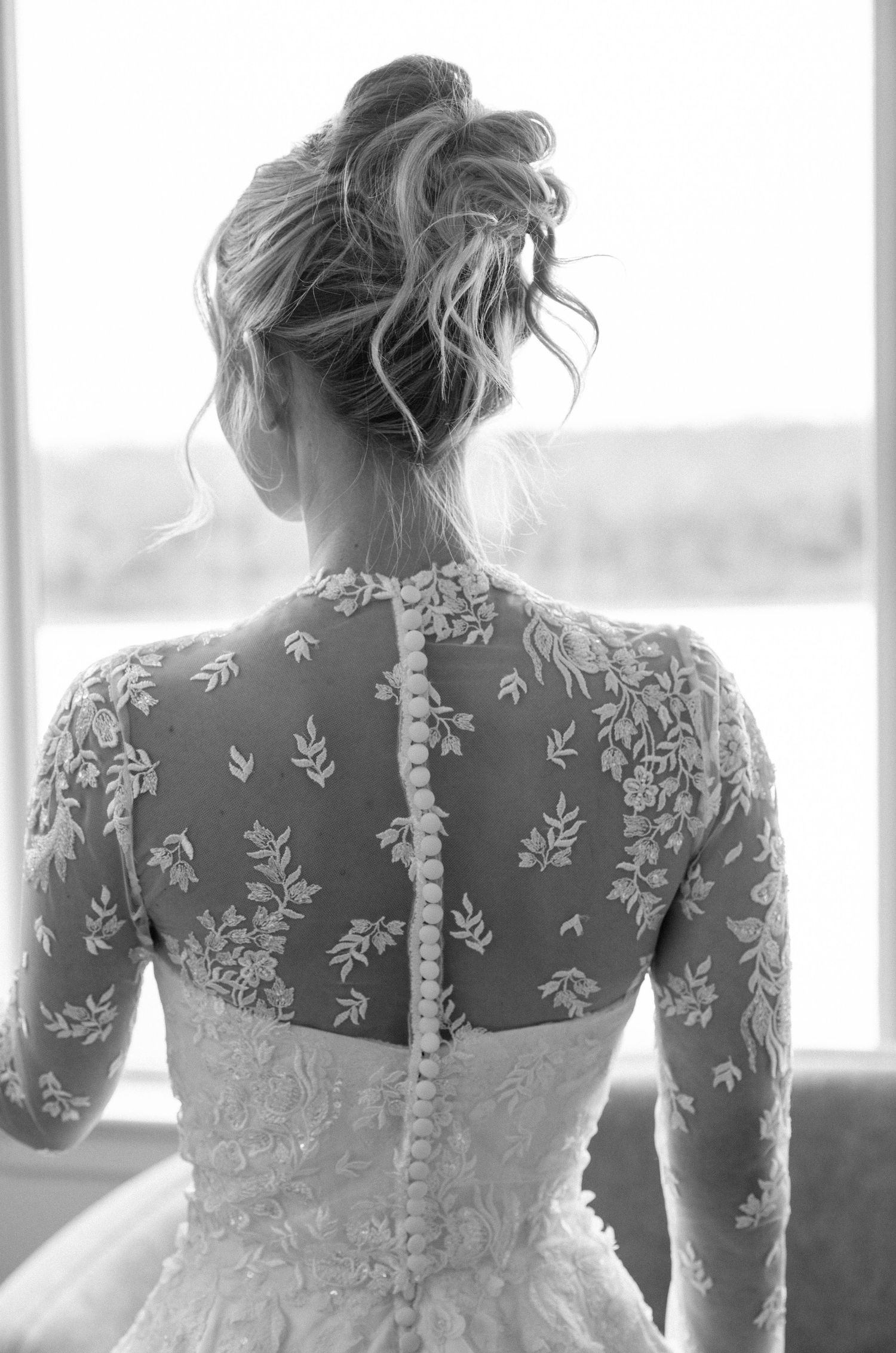 Detailed back of wedding gown showing intricate lace and button details.