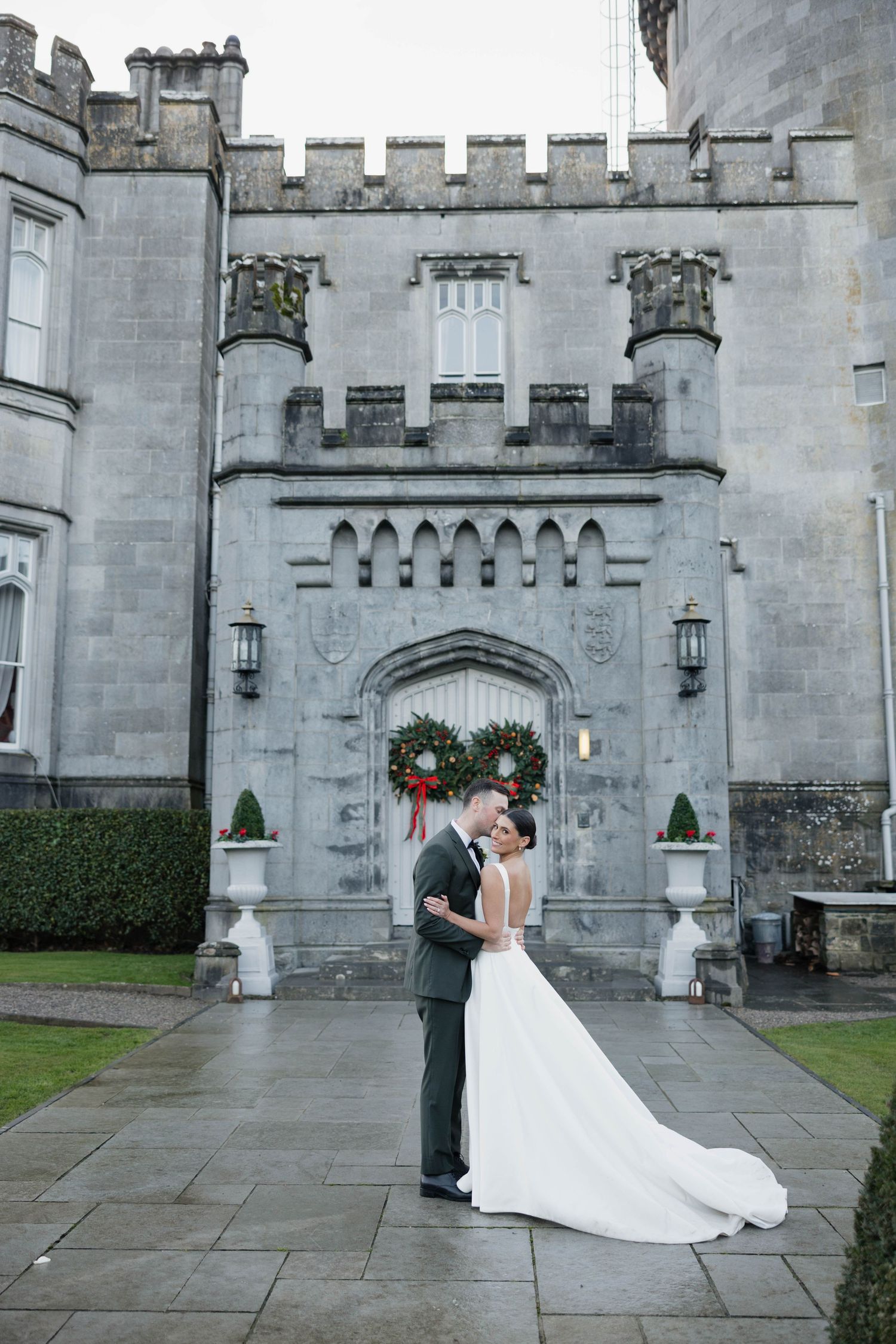 A wedding photo sequence in front of a gothic castle entrance with stone walls and archways.