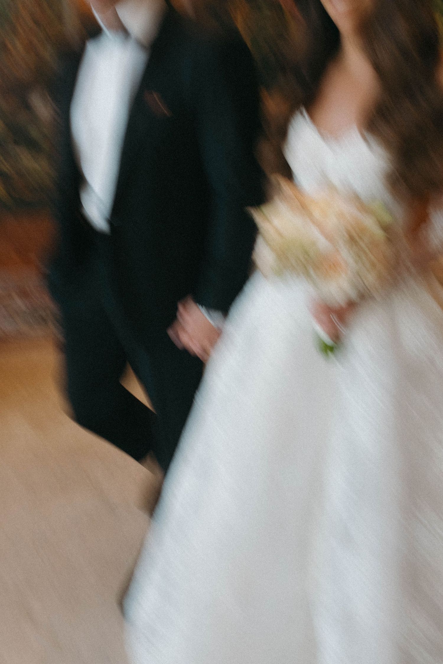 Motion-blurred artistic wedding photography in an indoor setting.