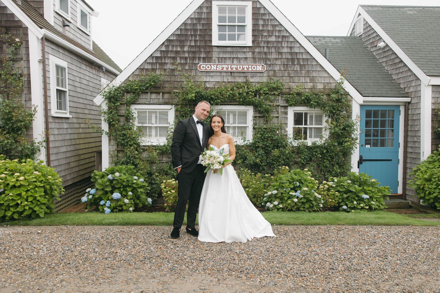 Series of romantic wedding poses captured along cottage row with coastal architecture.