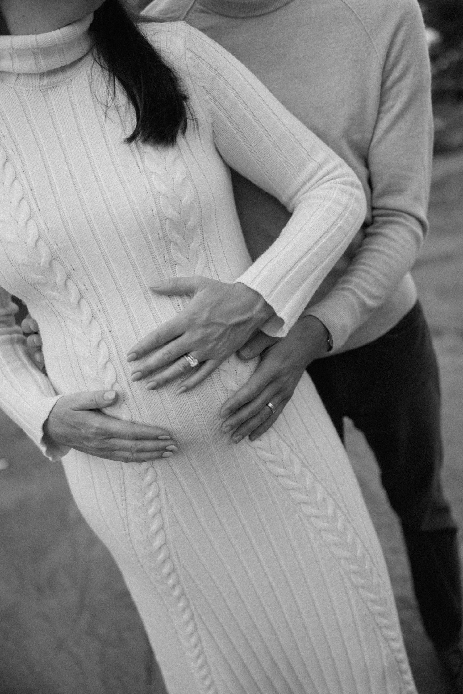 Black and white series showing a woman's pregnant belly in a cable knit sweater.