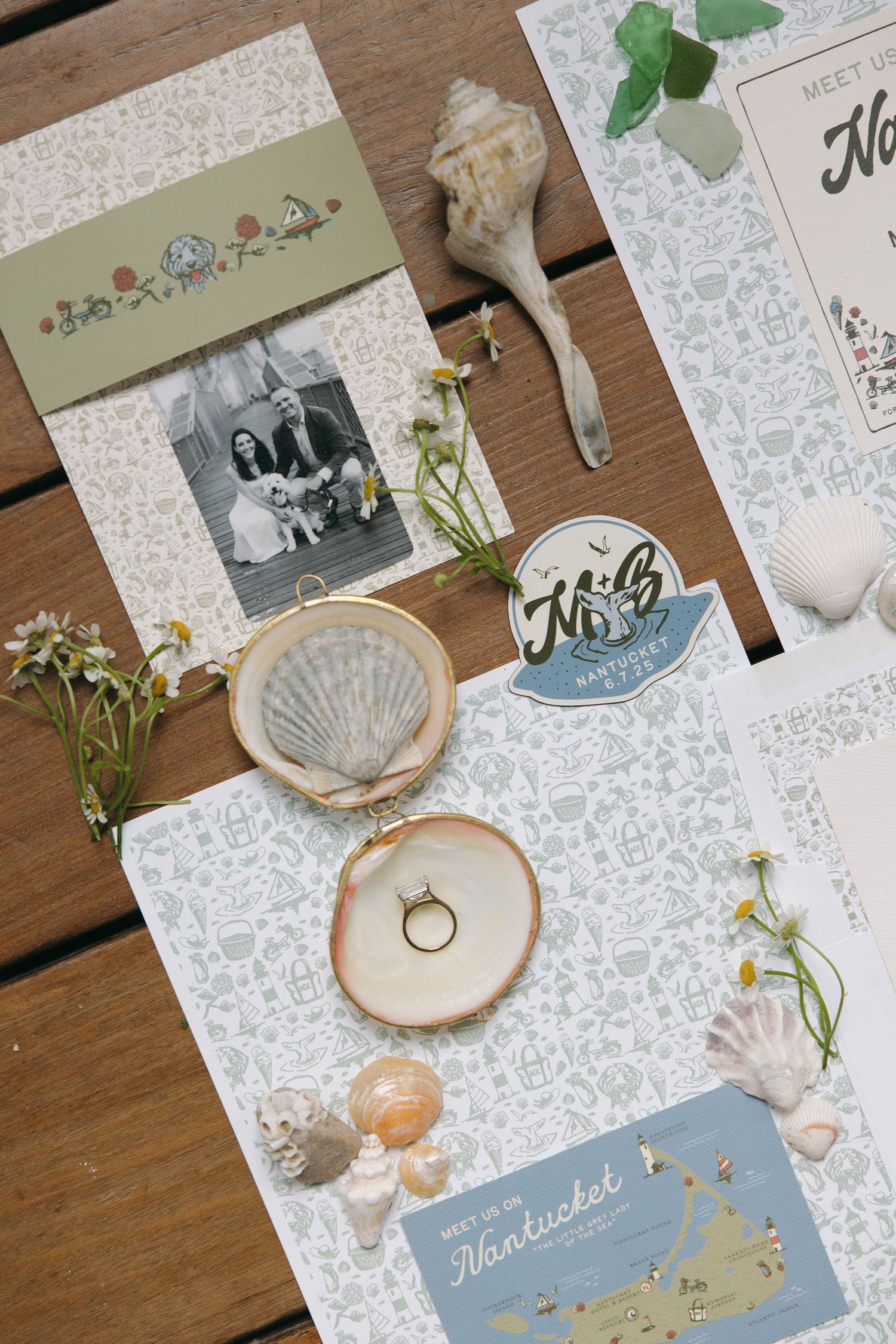 Wedding invitation flat lay with seashells, wooden rings holder, and Nantucket-themed stationery.