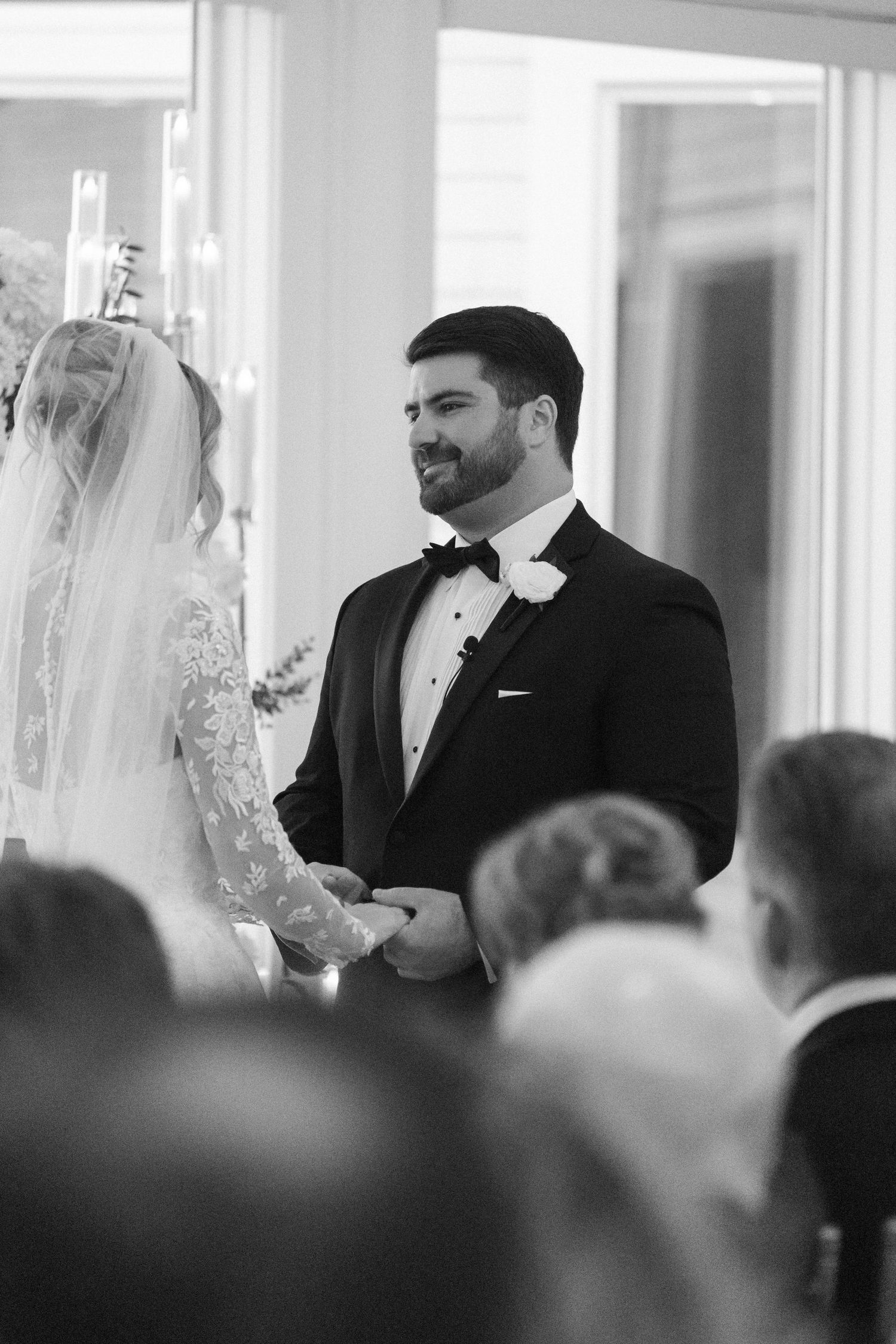 Black and white photograph of a wedding ceremony with guests watching the proceedings.