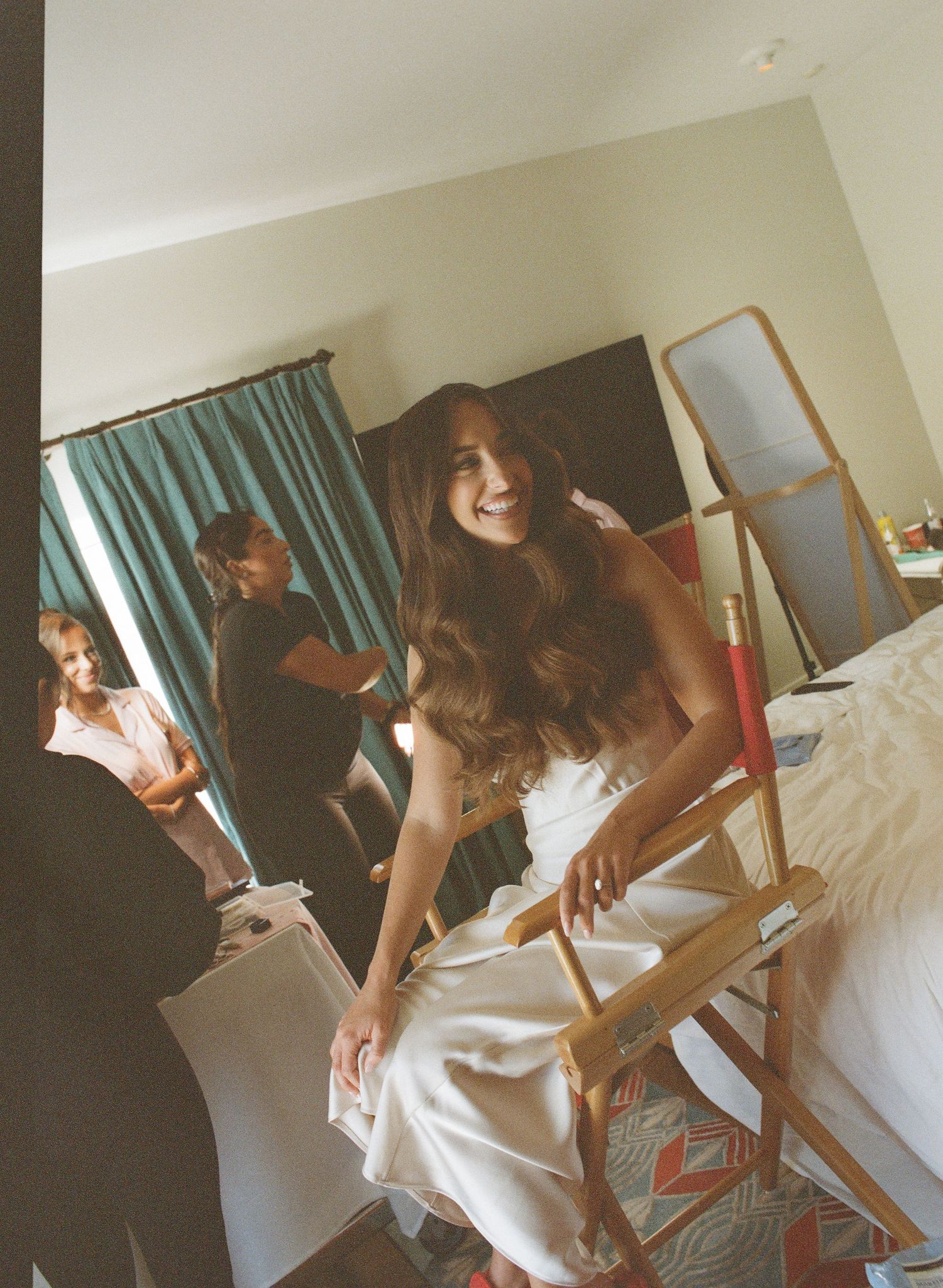 Candid moments of wedding preparations in a bright hotel room with white decor.
