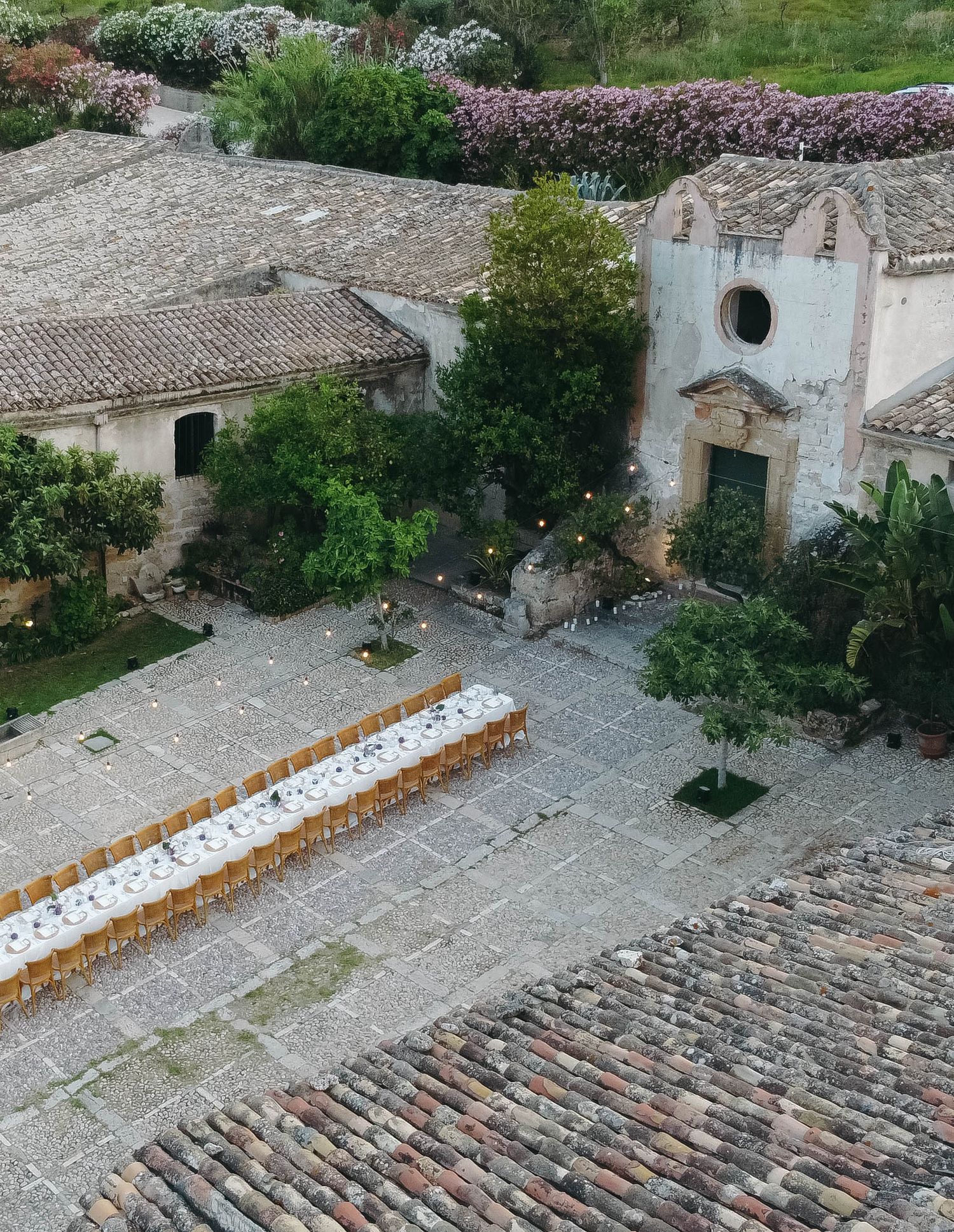 Historic stone buildings and tiled roofs in a Mediterranean coastal settlement viewed from above.
