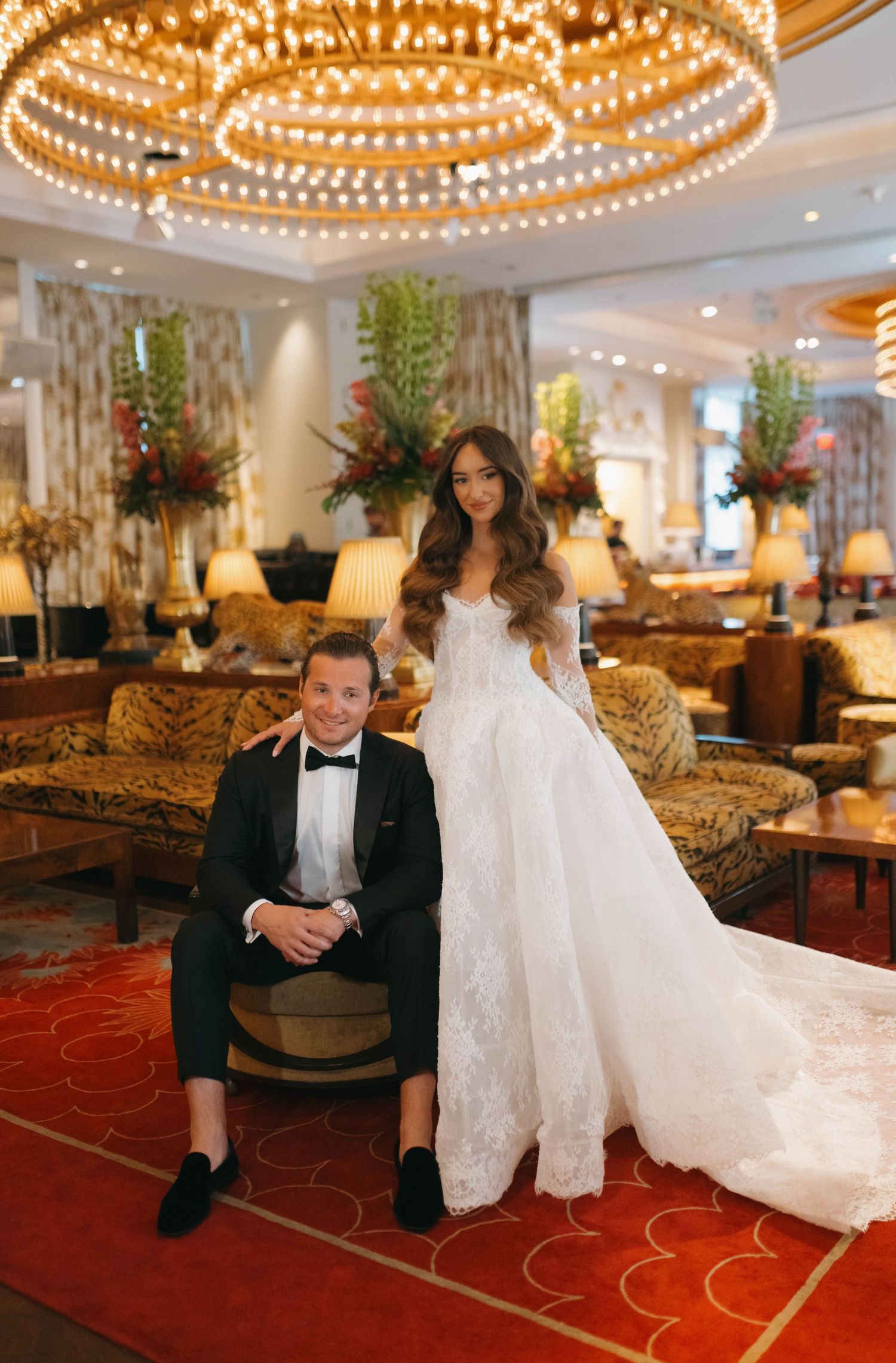 Playful wedding portraits captured in an elegant hotel lobby with dramatic lighting.