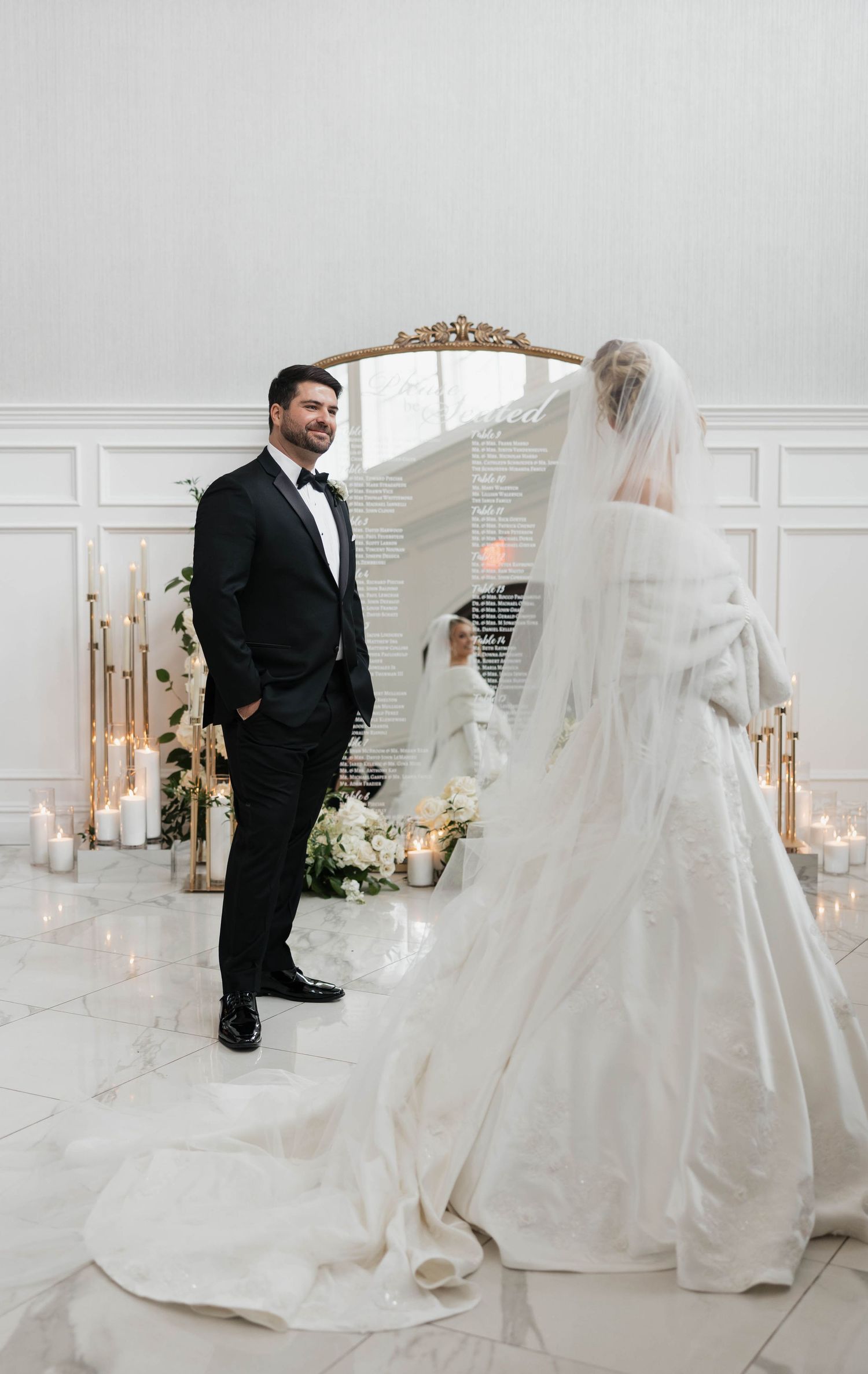 Dramatic wedding portraits in an all-white room with flowing veil and romantic lighting.