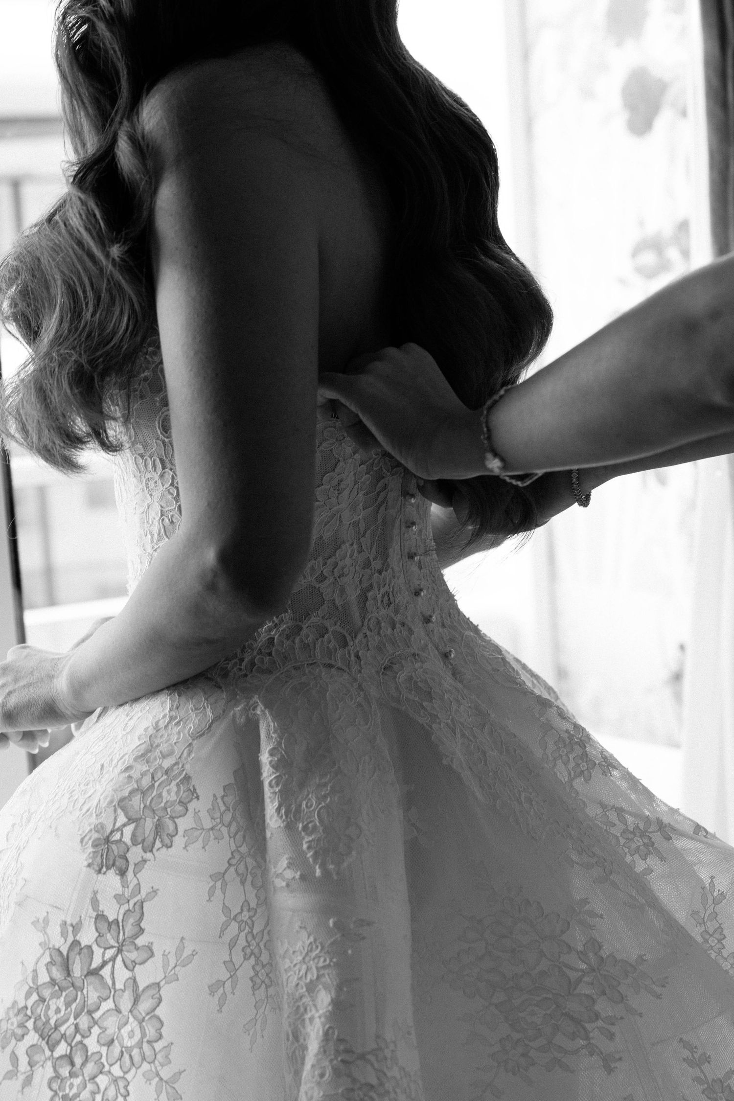 Close-up details of intricate lace pattern on white wedding dress.