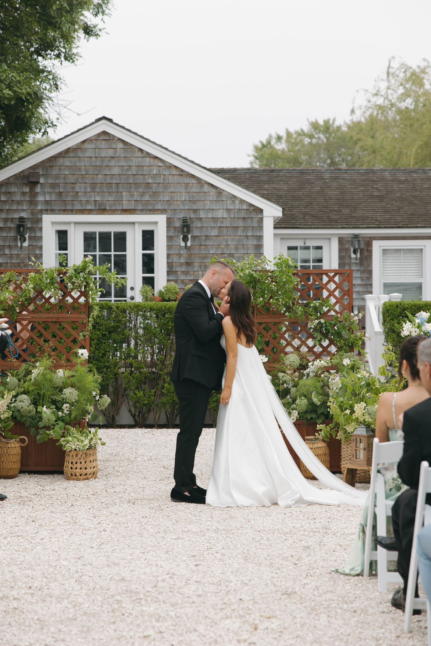 Wedding ceremony progression shown in sequence outside gray shingled house.