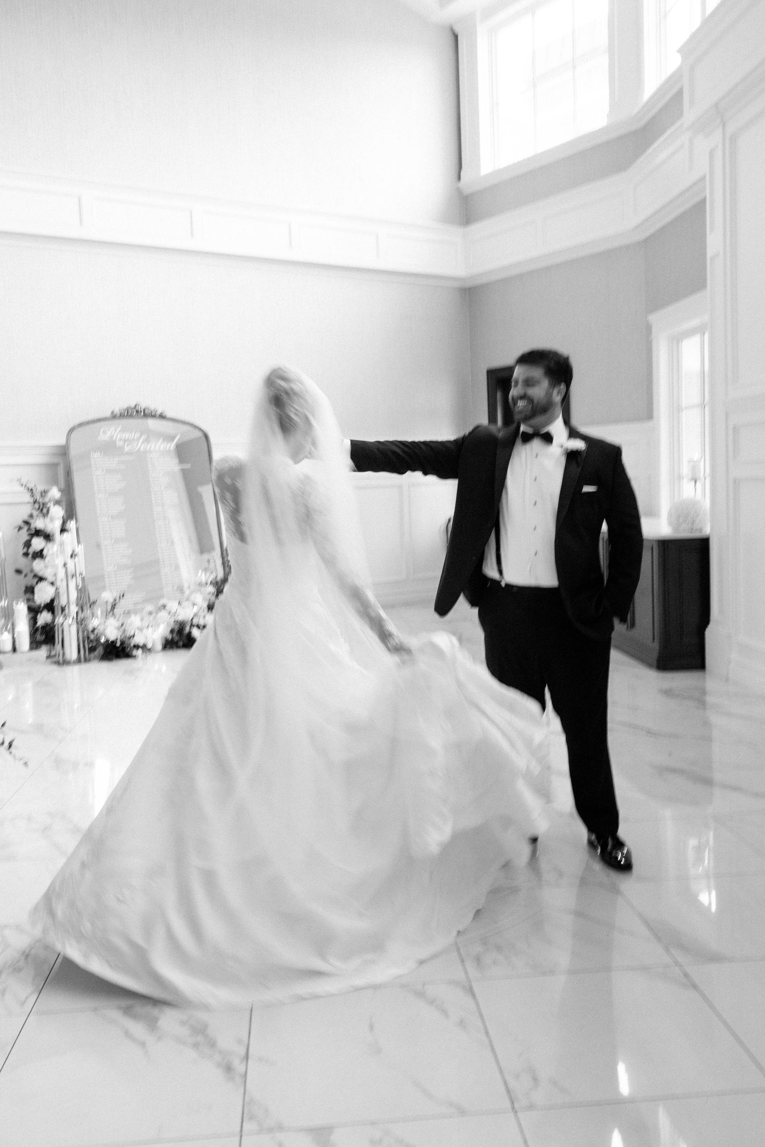 Dynamic black and white wedding photos showing movement and joy in a bright space.