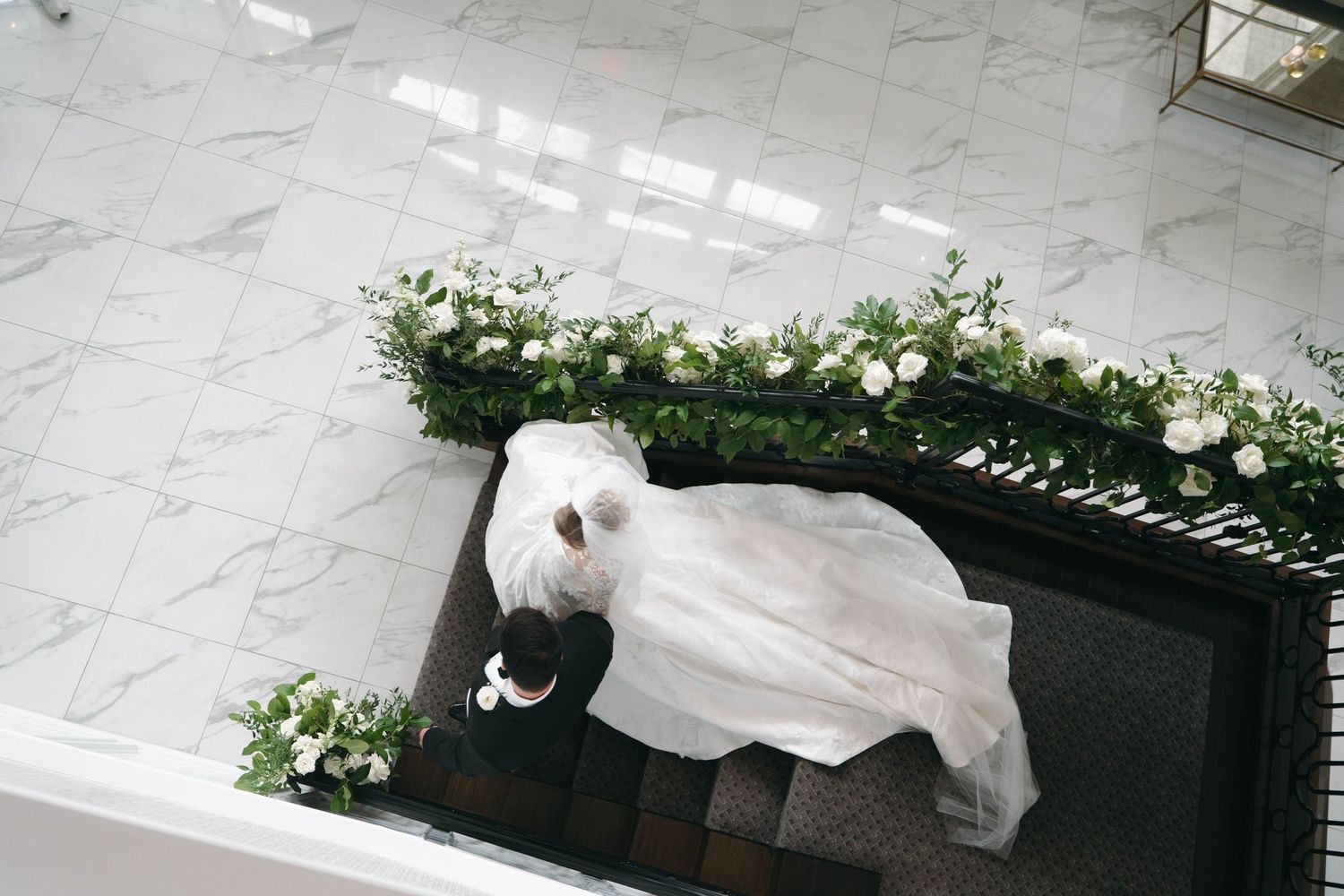 Wedding venue decorated with white floral arrangements and elegant marble flooring.