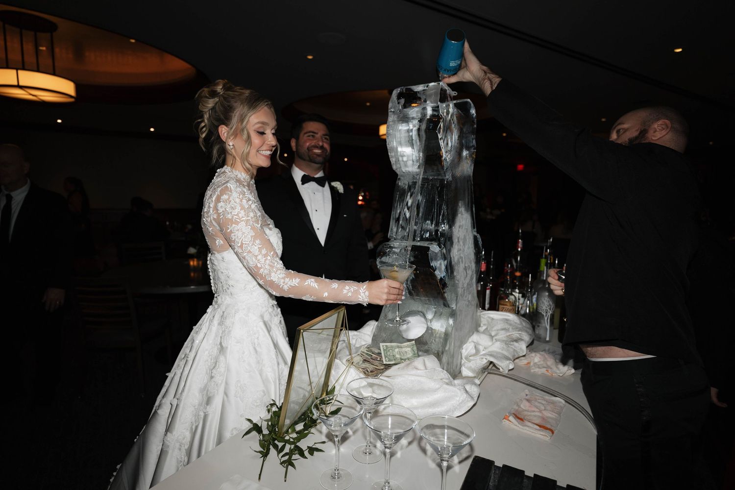 Wedding reception scene showing tables set with glassware and floral centerpieces.