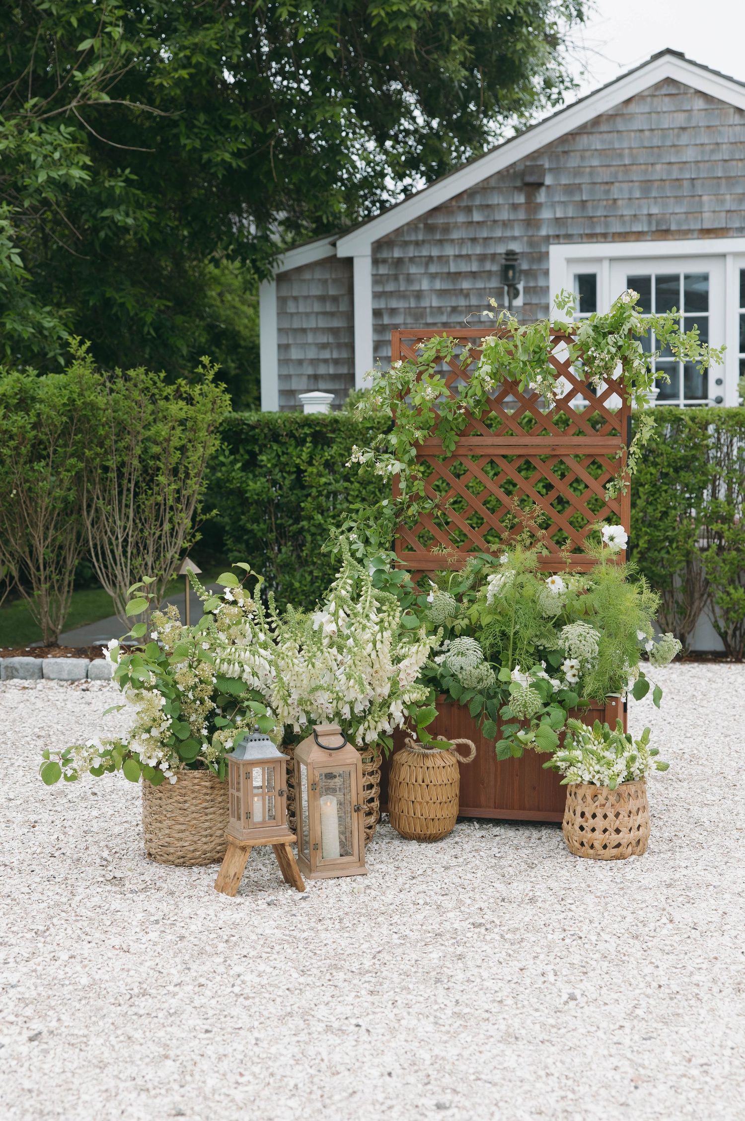 Rustic wedding decor featuring woven baskets with floral arrangements and wooden lattice screens.