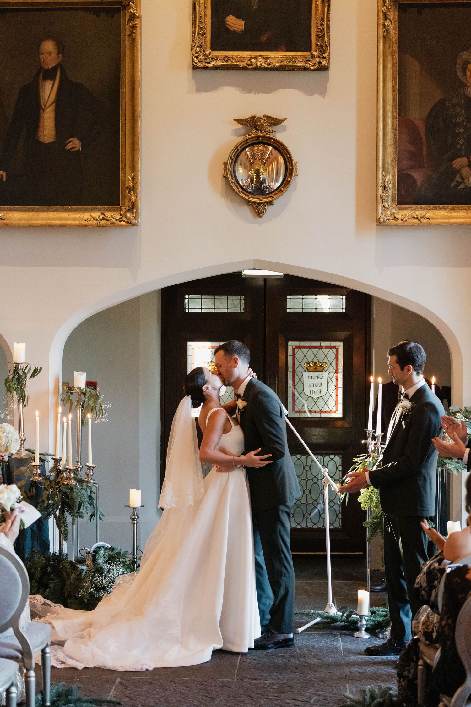 A series of wedding ceremony moments captured in an elegant hall with portrait-lined walls.
