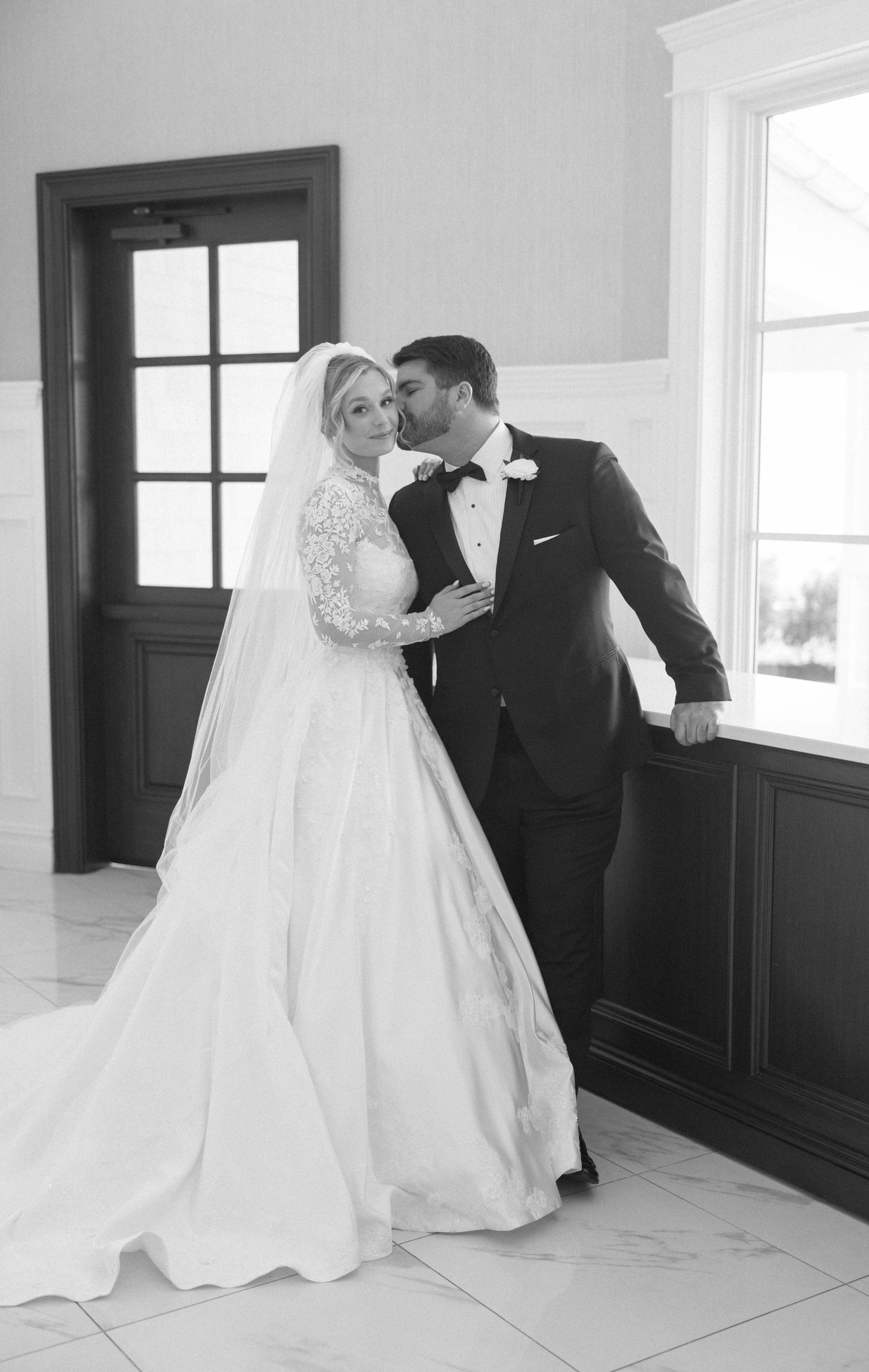 Black and white wedding photos showing romantic first look moments in an elegant indoor setting.
