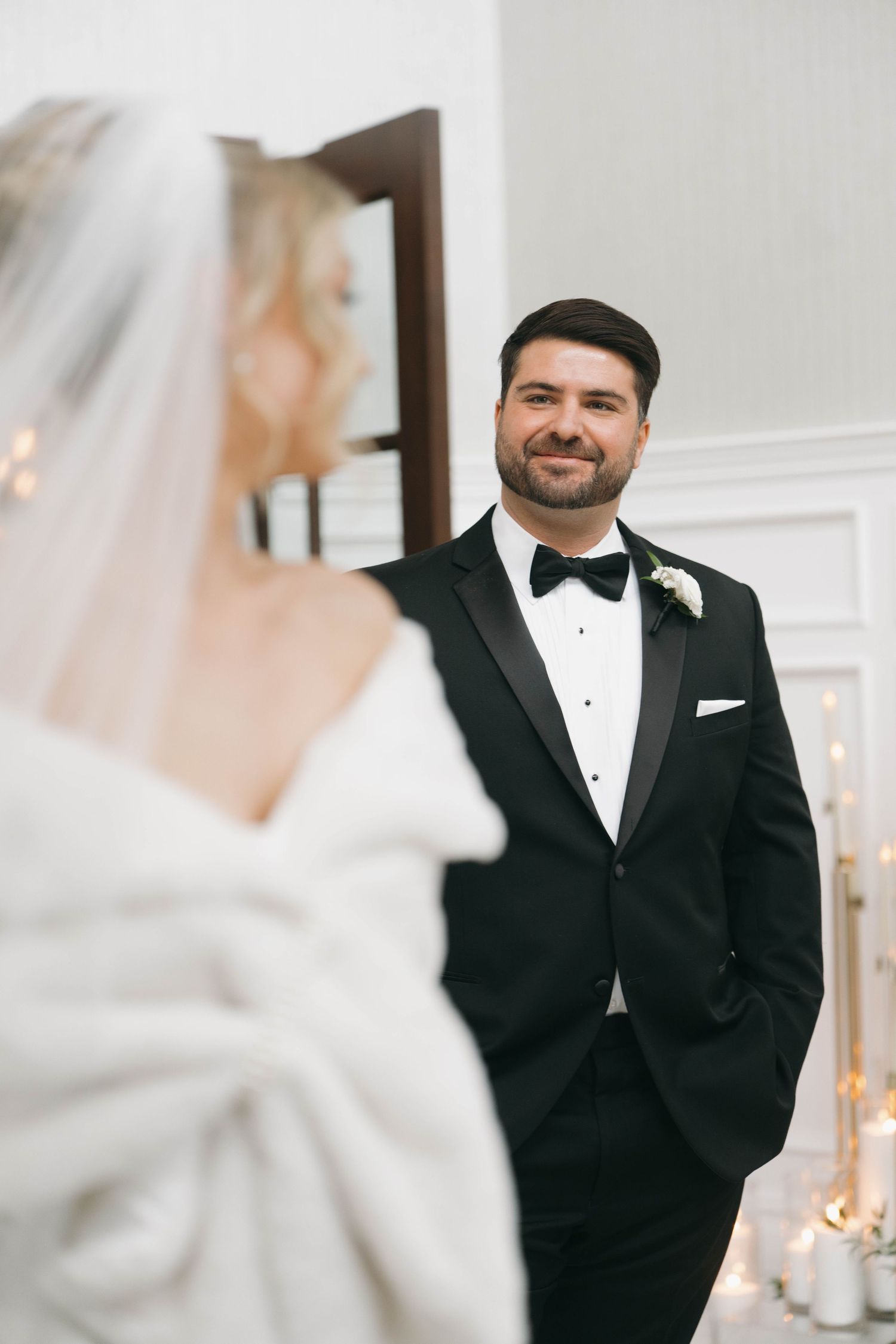 A groom's emotional reaction during the first look moment at an indoor wedding venue.