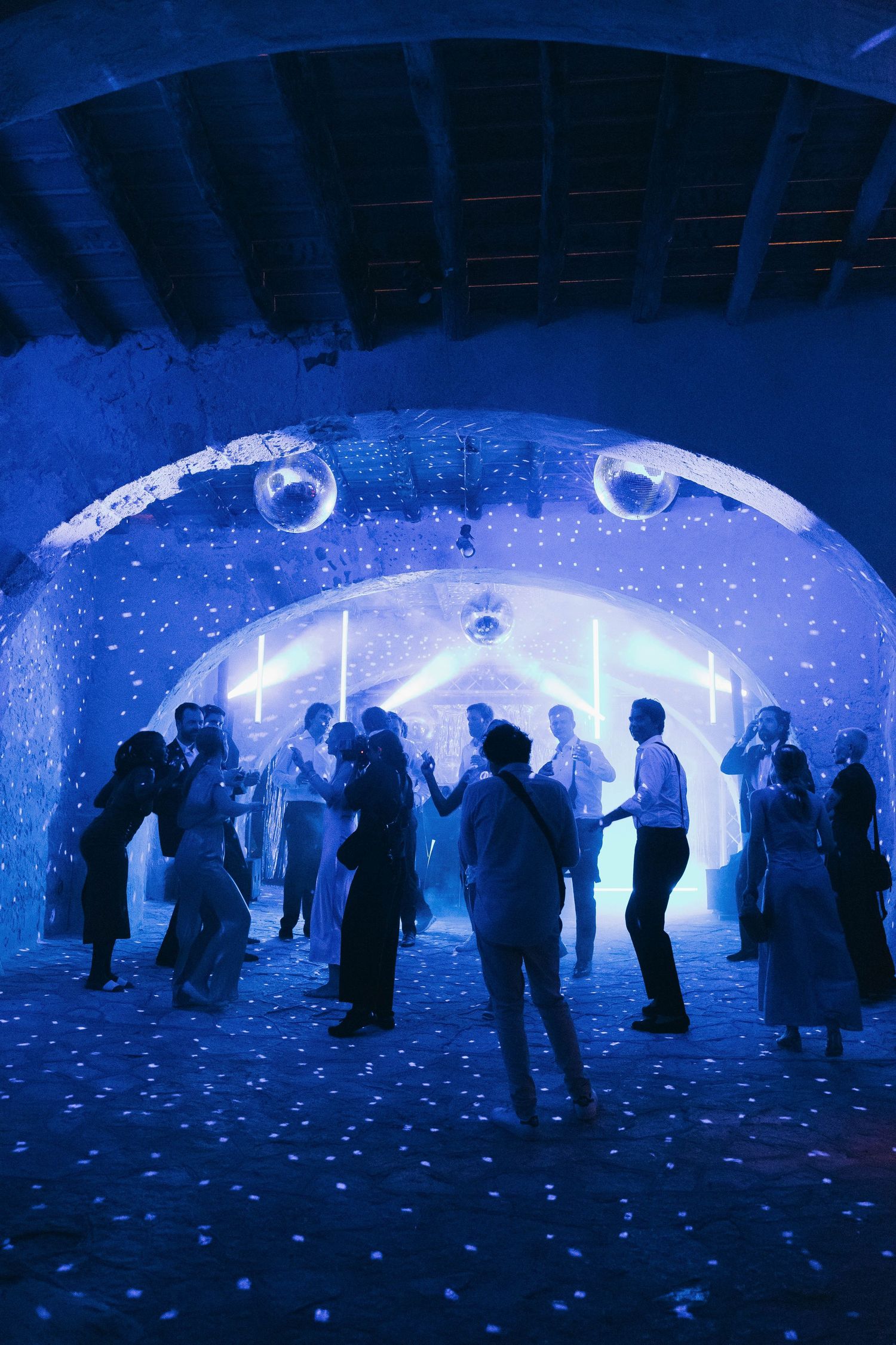 People standing beneath a curved ceiling with blue lighting and star-like projections.