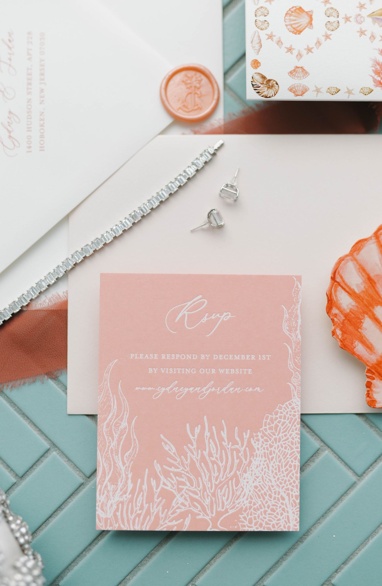 Coral and white wedding invitation with sea coral design and crystal jewelry.