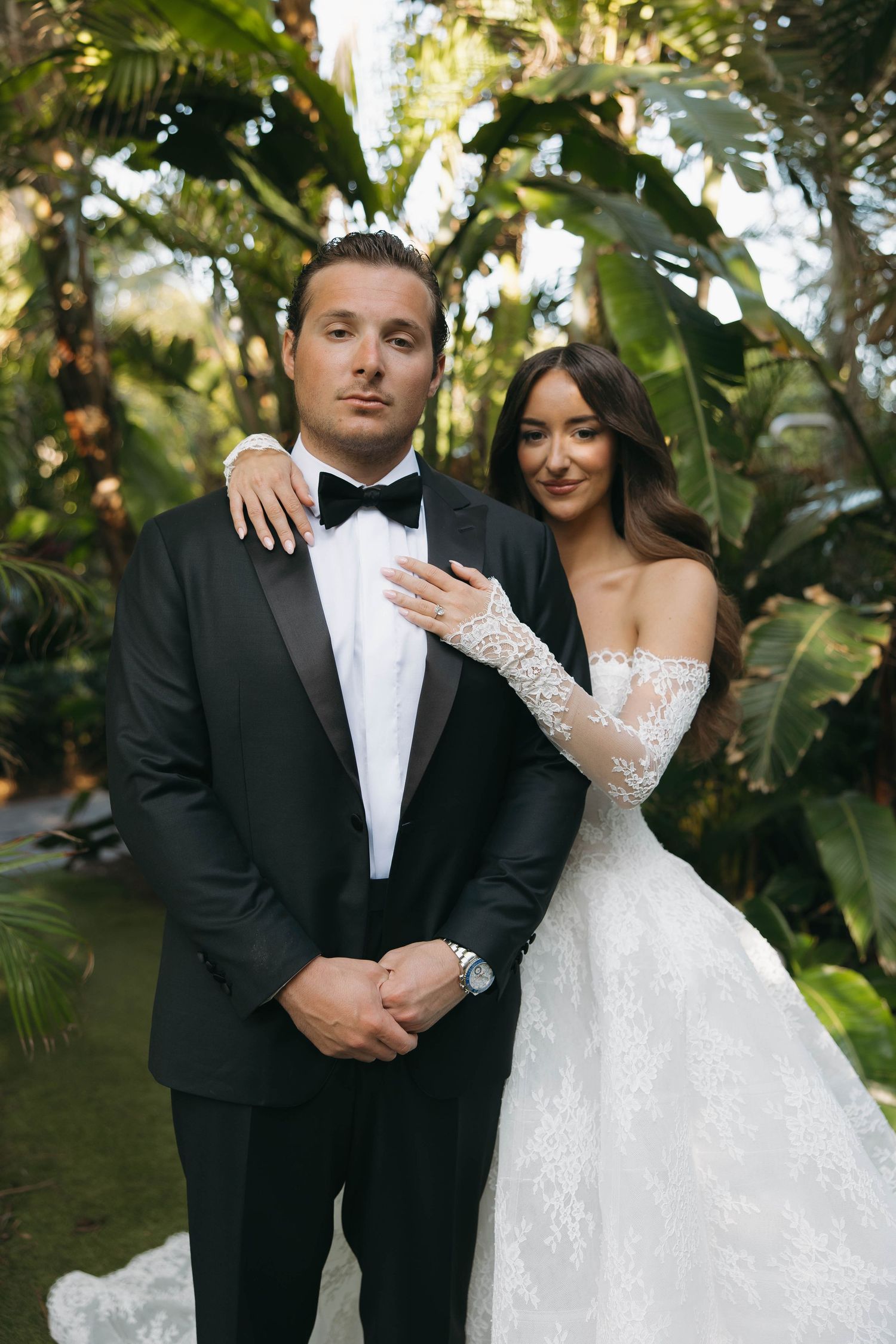 Wedding couple shares intimate moments in a lush tropical garden setting.
