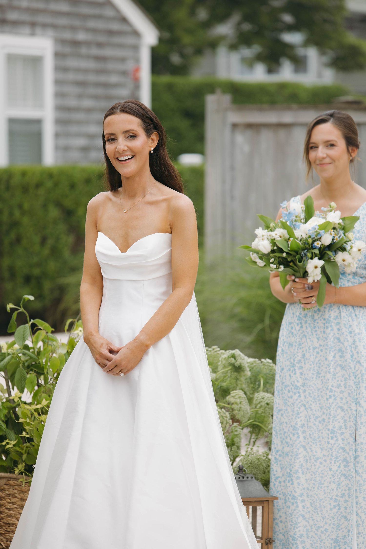 Bridesmaids in light blue dresses stand with bride in white gown at outdoor ceremony.