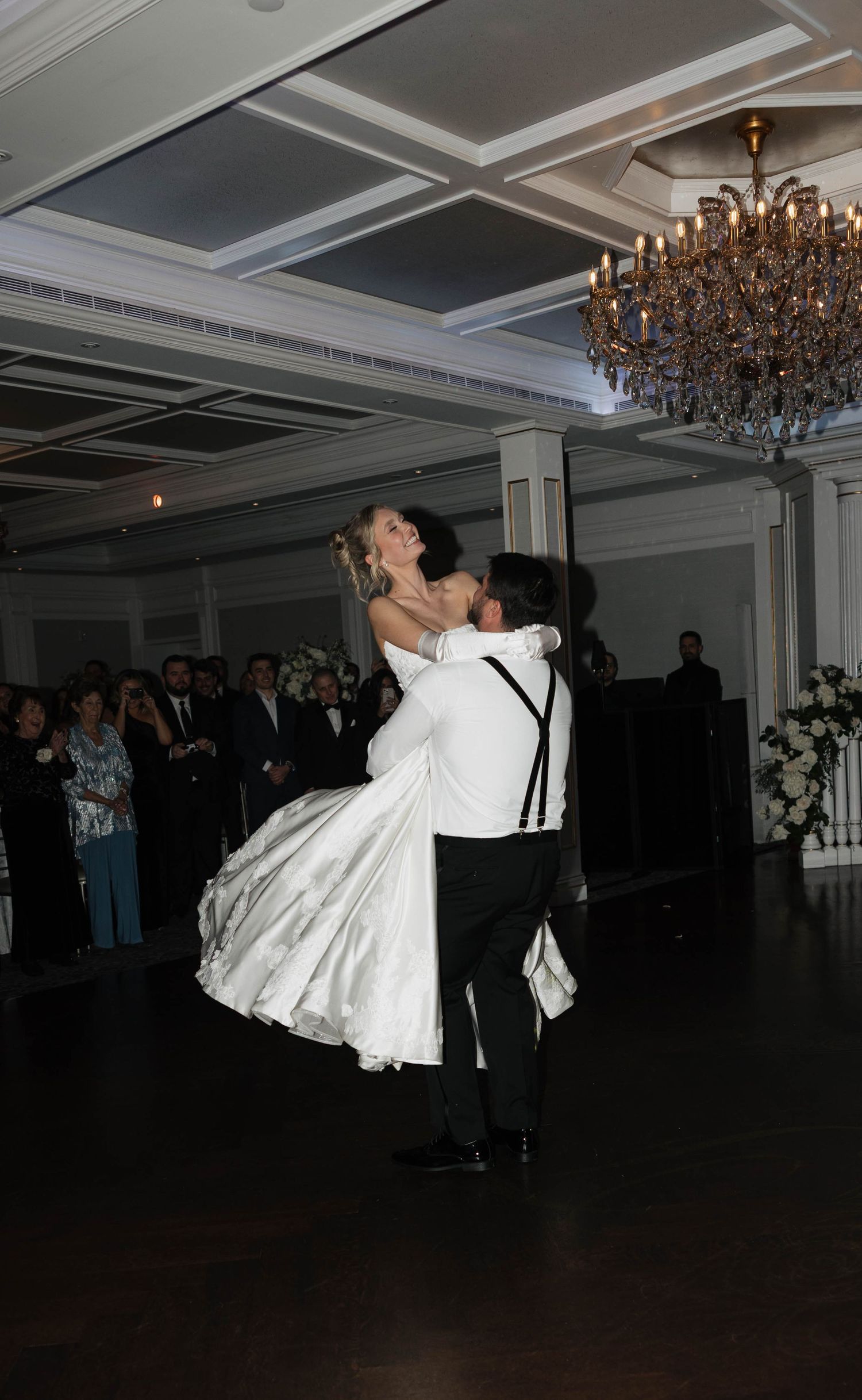 Wedding couple performs dramatic dance moves during their first dance in a ballroom.