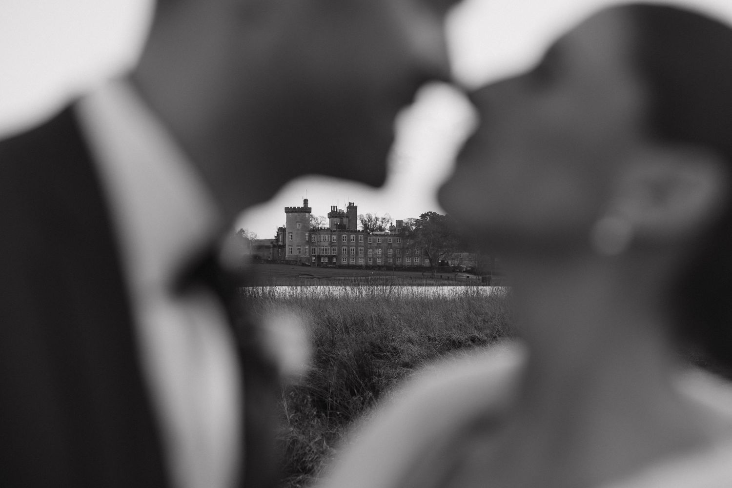 Artistic wedding photography with a castle silhouette in soft focus.