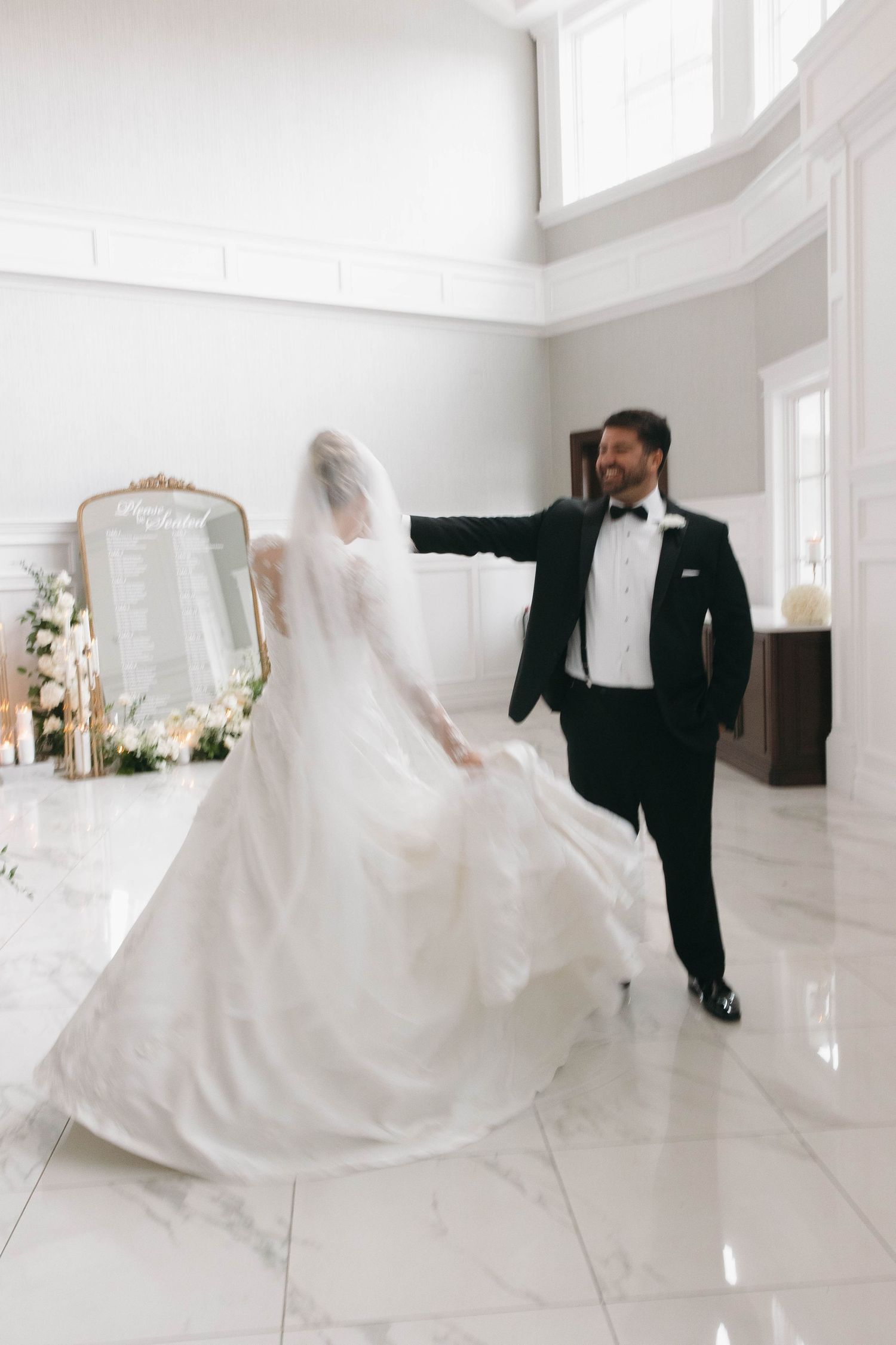 Artistic wedding photos showing movement and dance in a bright white space.