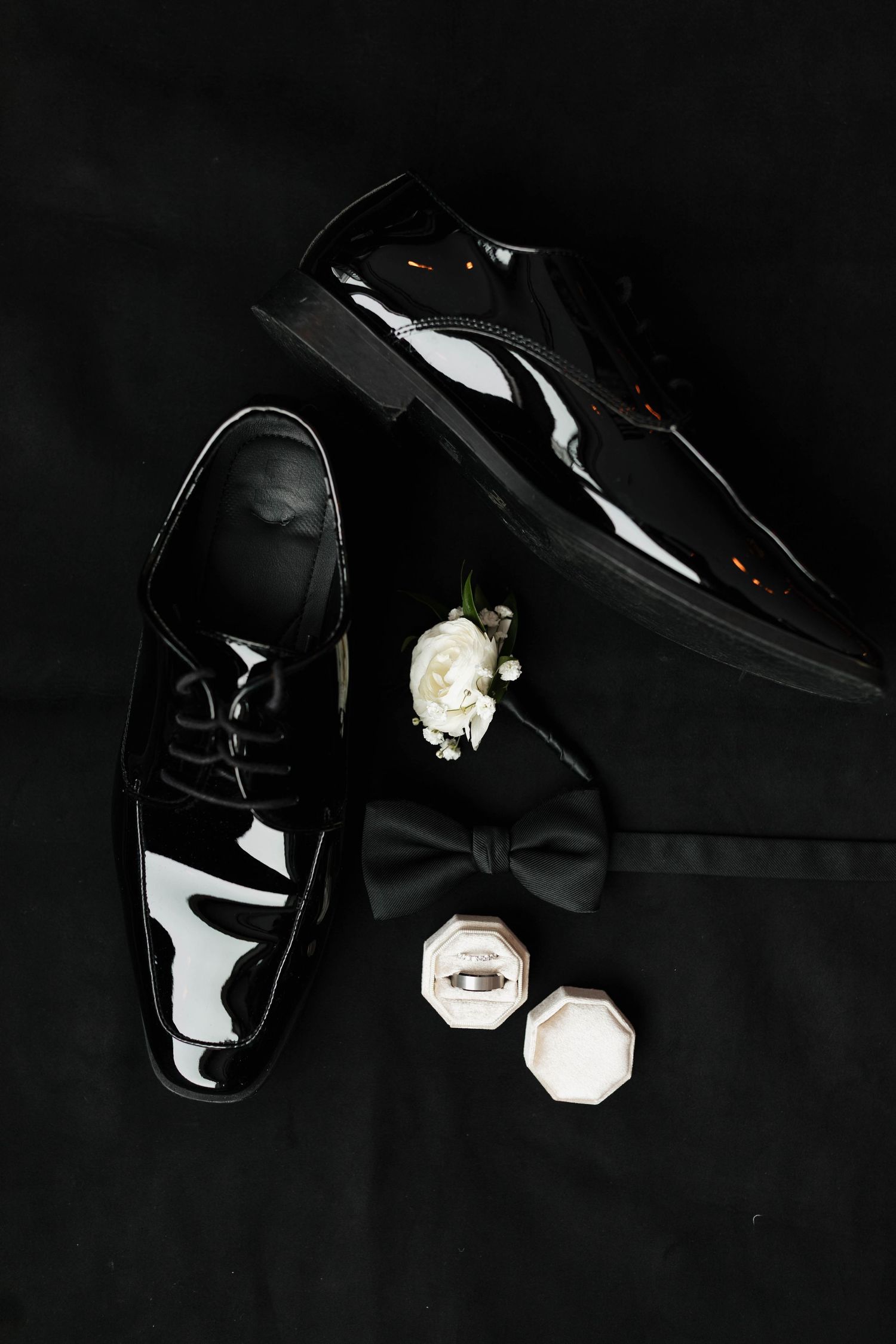 Close-up details of elegant black bow ties and accessories against a dark background.